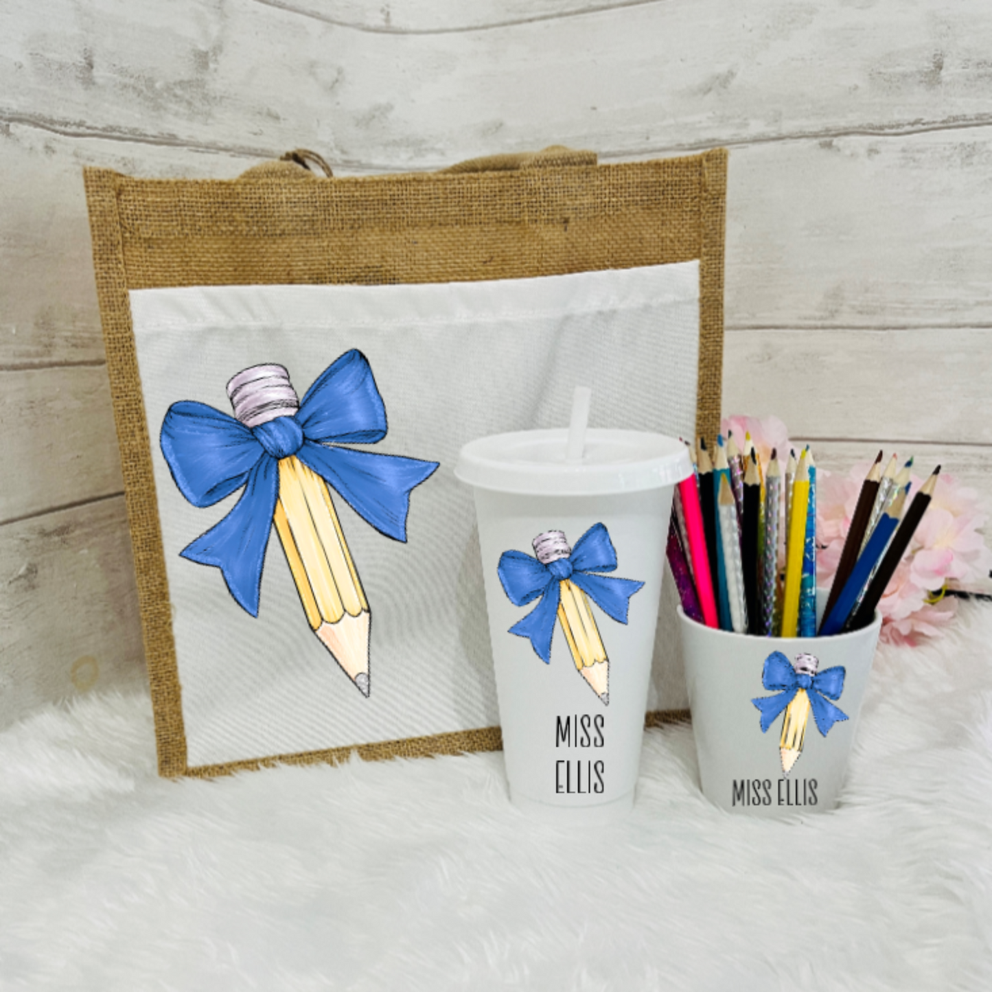 A set of personalized teacher's gifts including a jute bag with a bow and pencil design, a white cold cup with a bow and the name 'Miss Ellis', and a pencil pot with a bow design.
