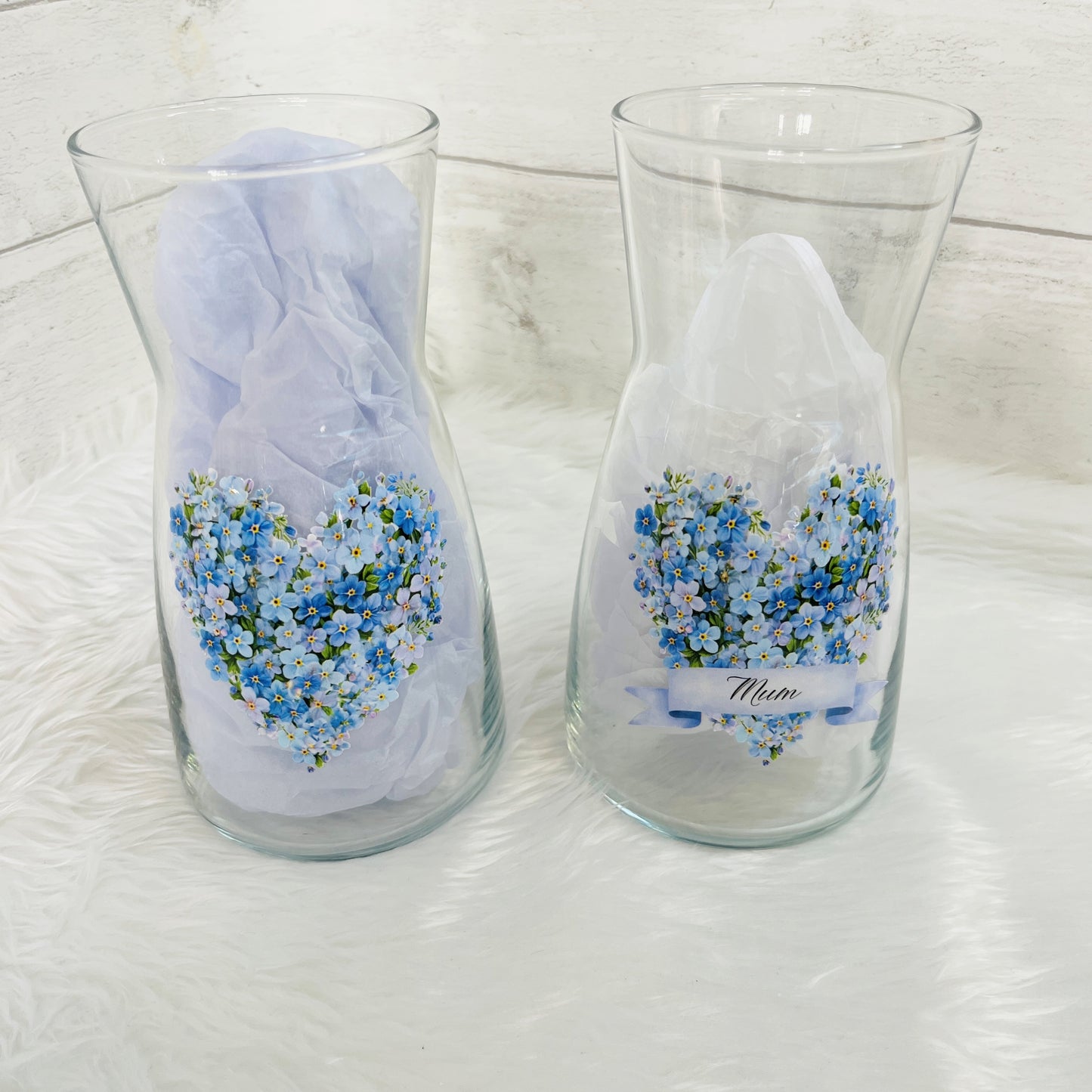 Two glass vases with forget me not design and the text 'mum' on the front against a white background