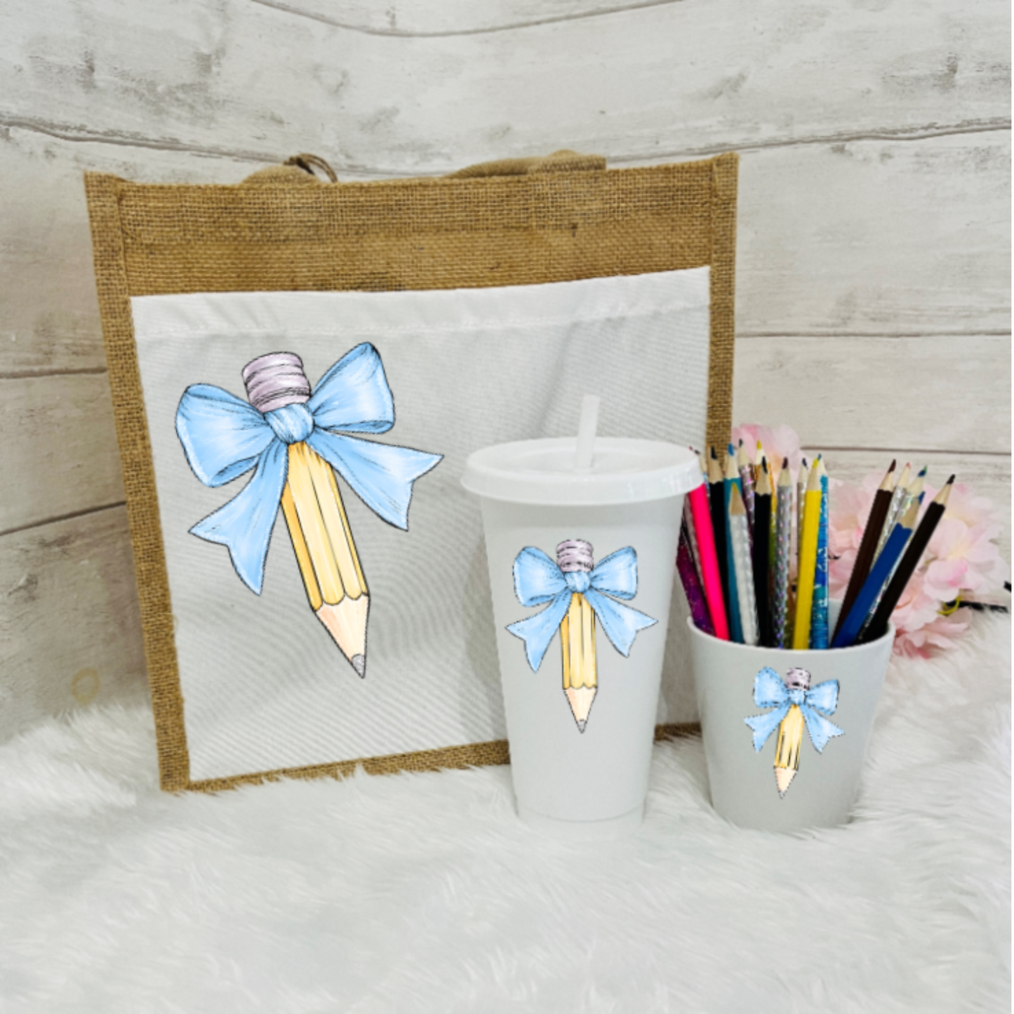 A set of personalized teacher's gifts including a jute bag with a bow and pencil design, a white cold cup with a bow and a pencil pot with a bow design in pale blue
