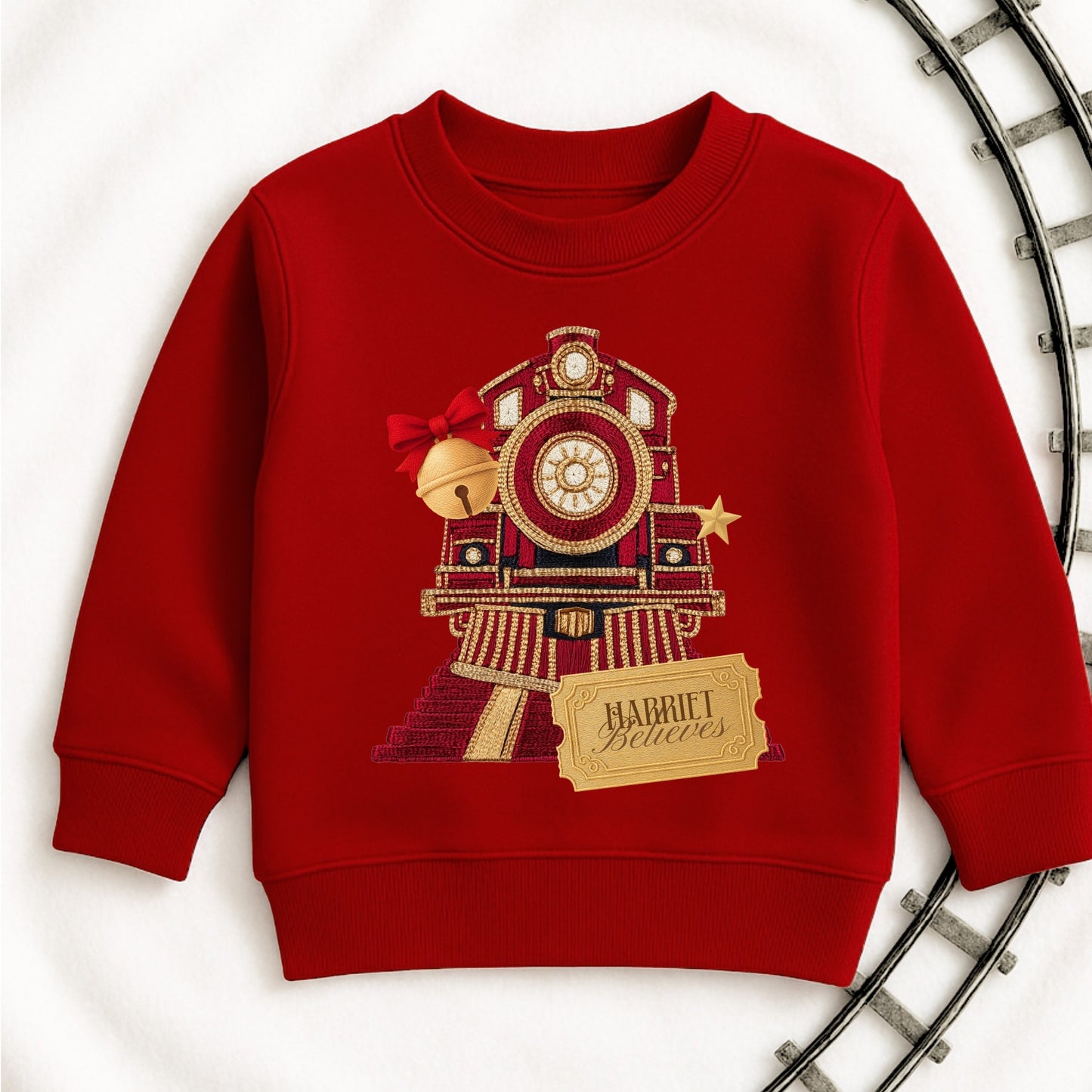 Red sweatshirt with a train design and 'Harriet Believes' text on a white background