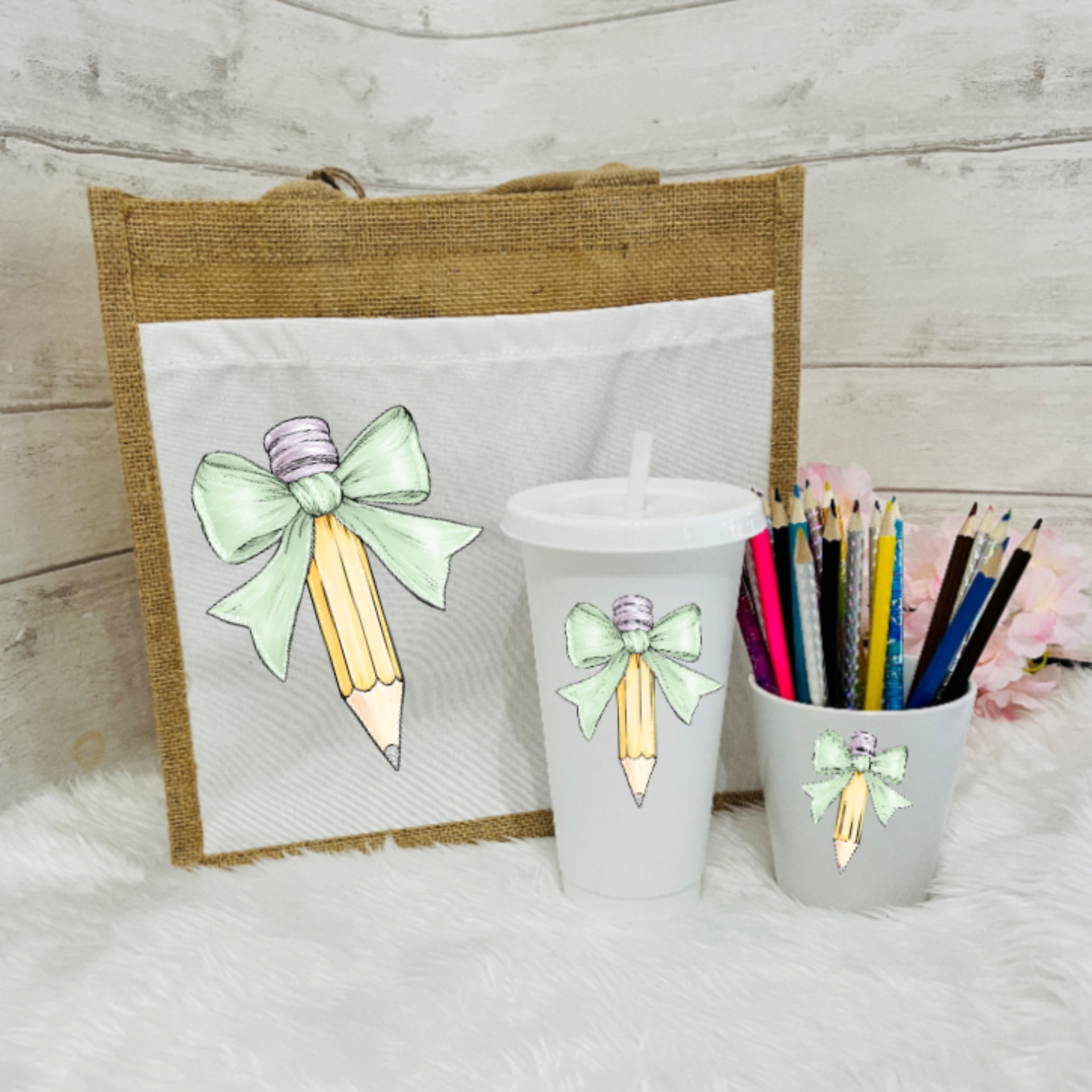 A set of personalized teacher's gifts including a jute bag with a bow and pencil design, a white cold cup with a bow and a pencil pot with pale green bow design.