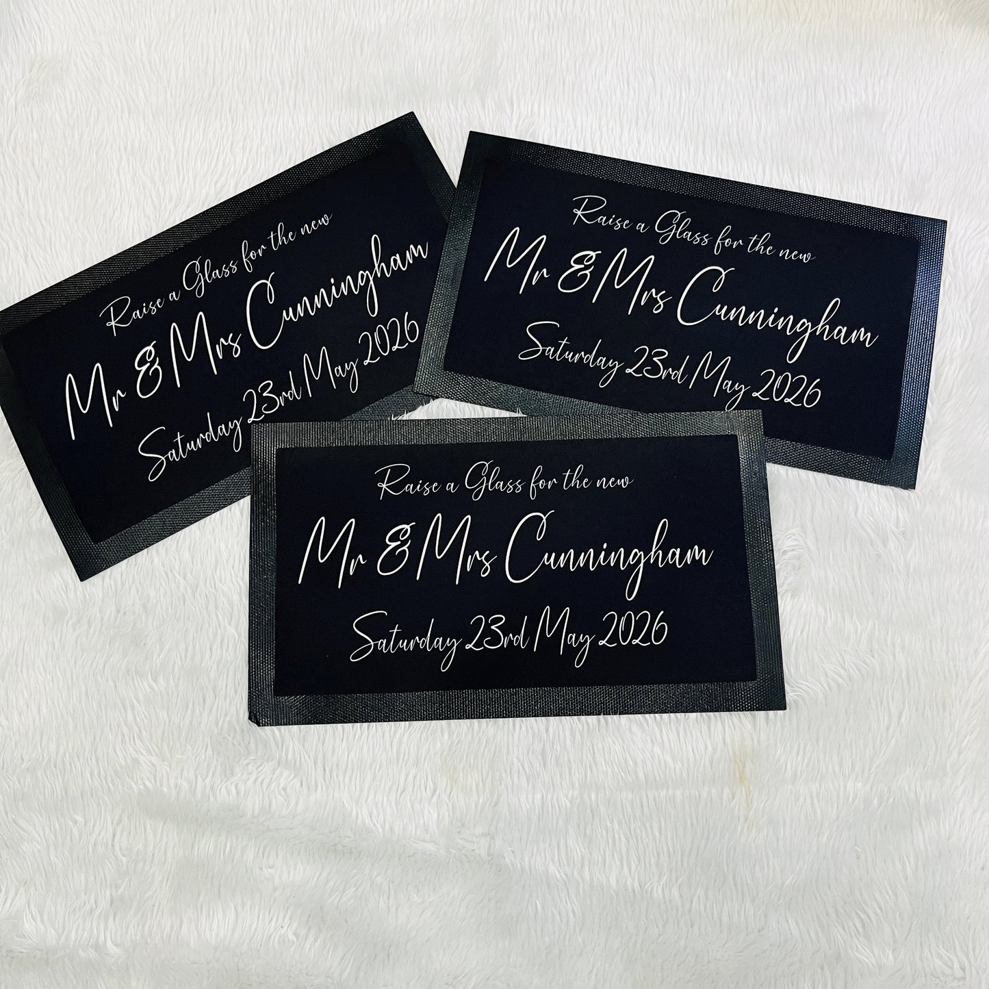 Three black beer mats with white text on a white background