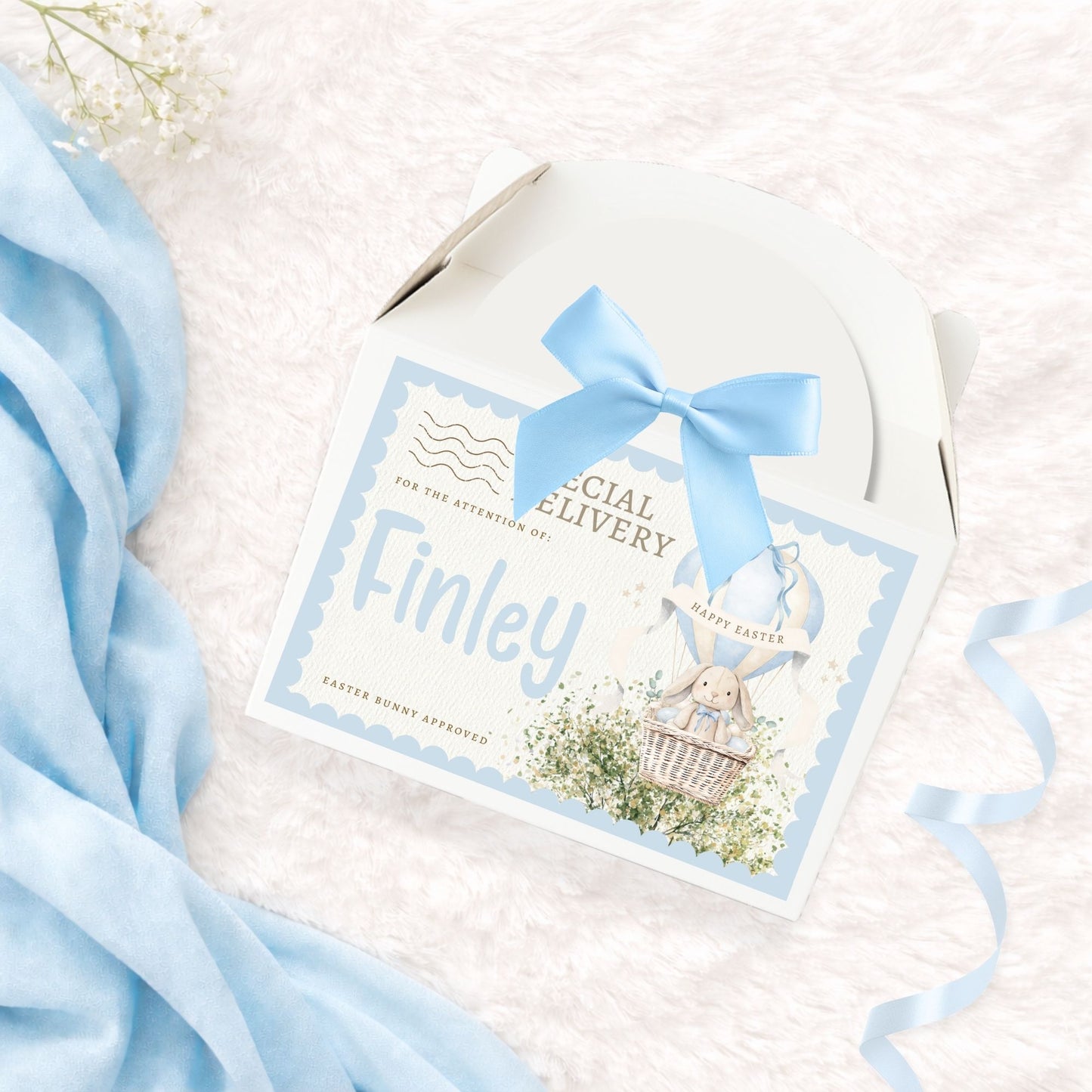 Cardboard treat box with 'special delivery' label, personalised name and matching blue bow on a white background with blue accents