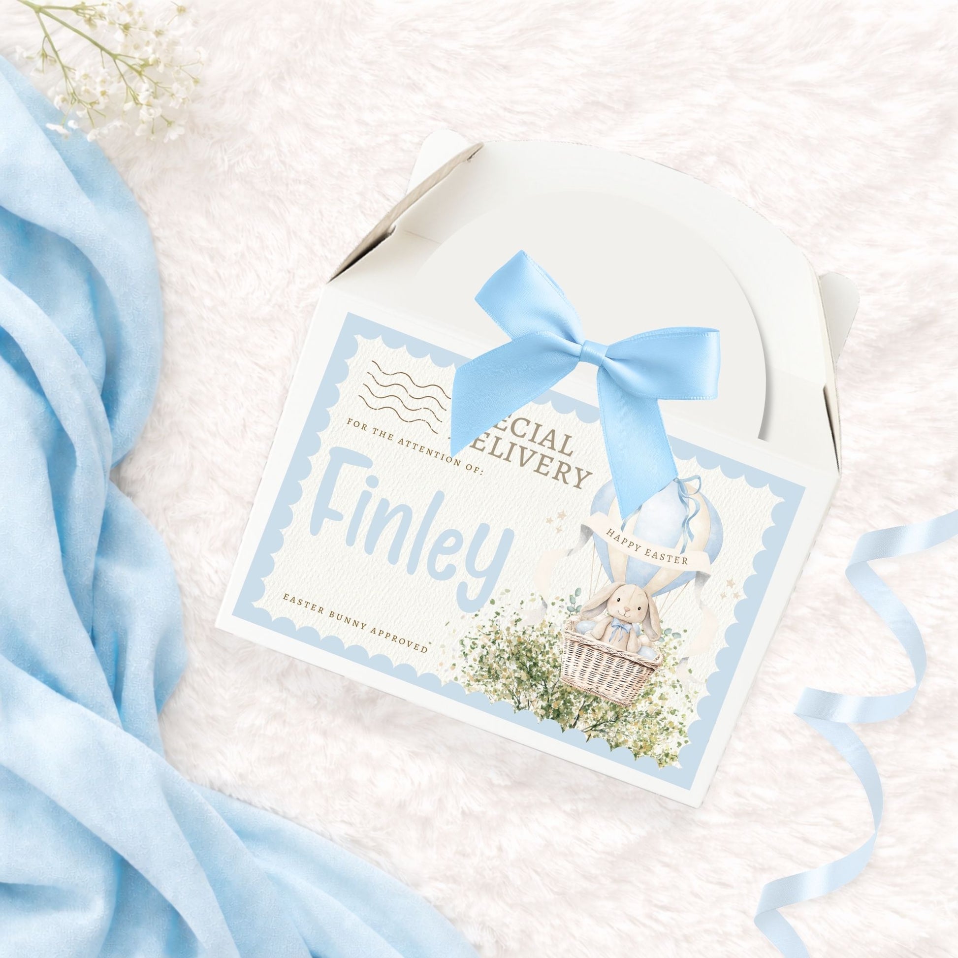 Cardboard treat box with 'special delivery' label, personalised name and matching blue bow on a white background with blue accents
