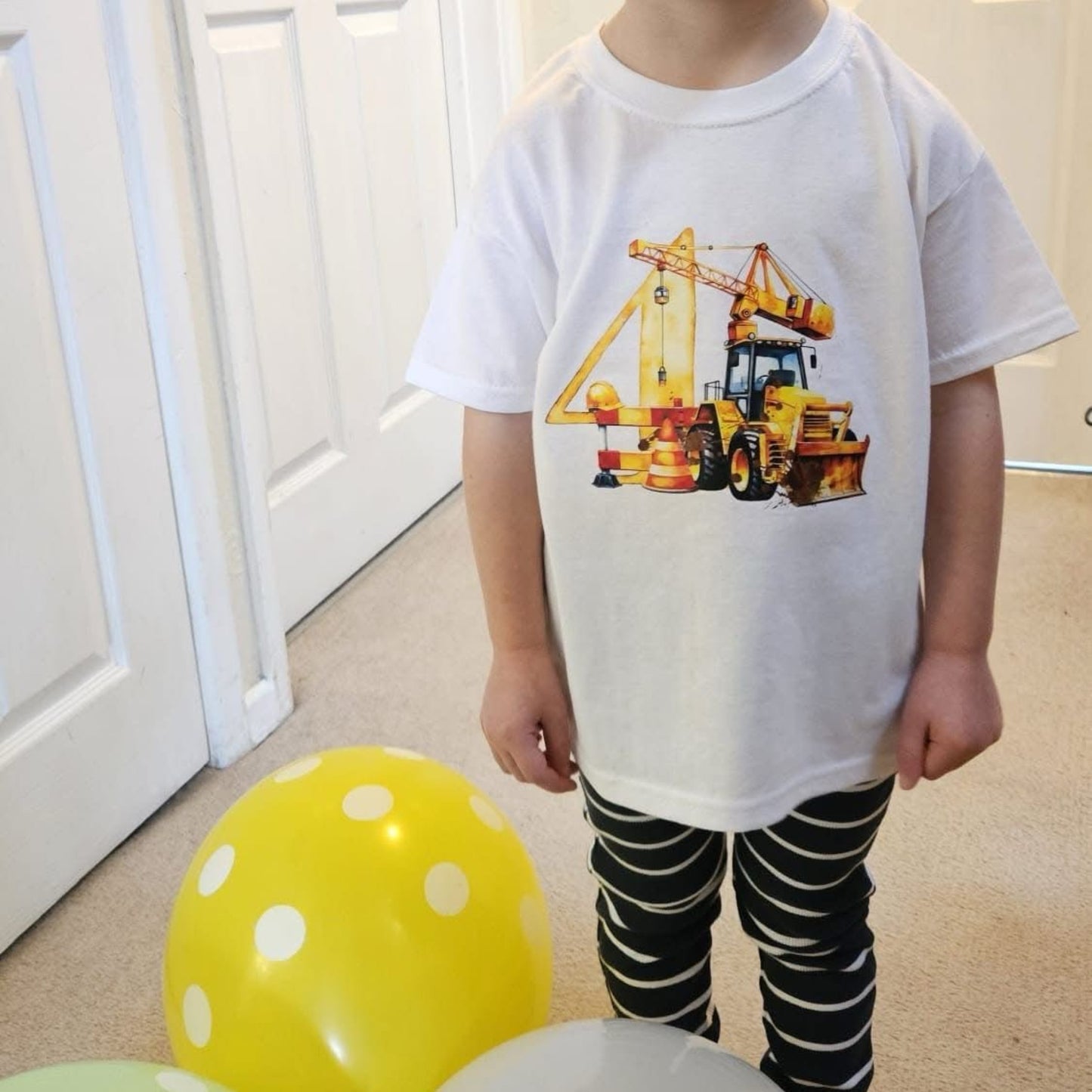 A customer photo of a child wearing a white T-shirt with the number 4 digger image on the front
