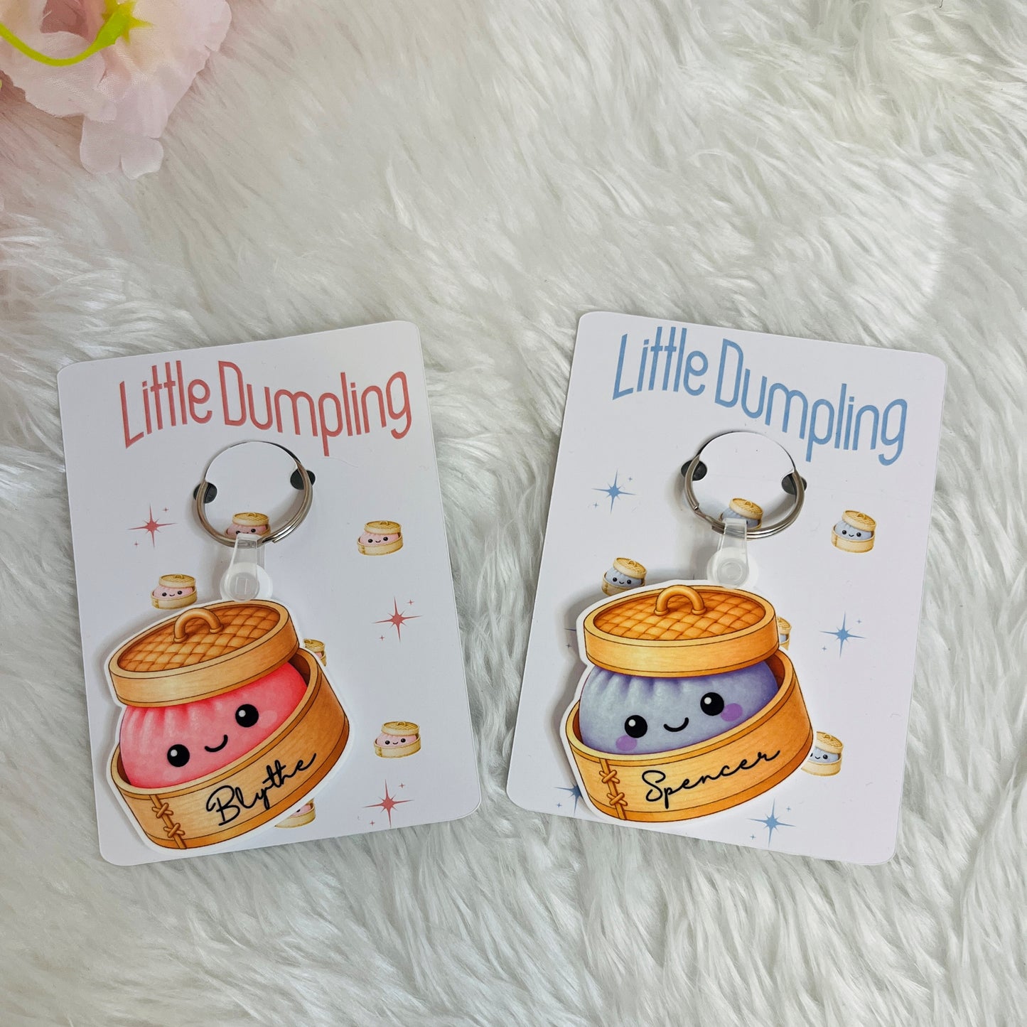 Two 'Little Dumpling' keychains on cards with a fluffy white background