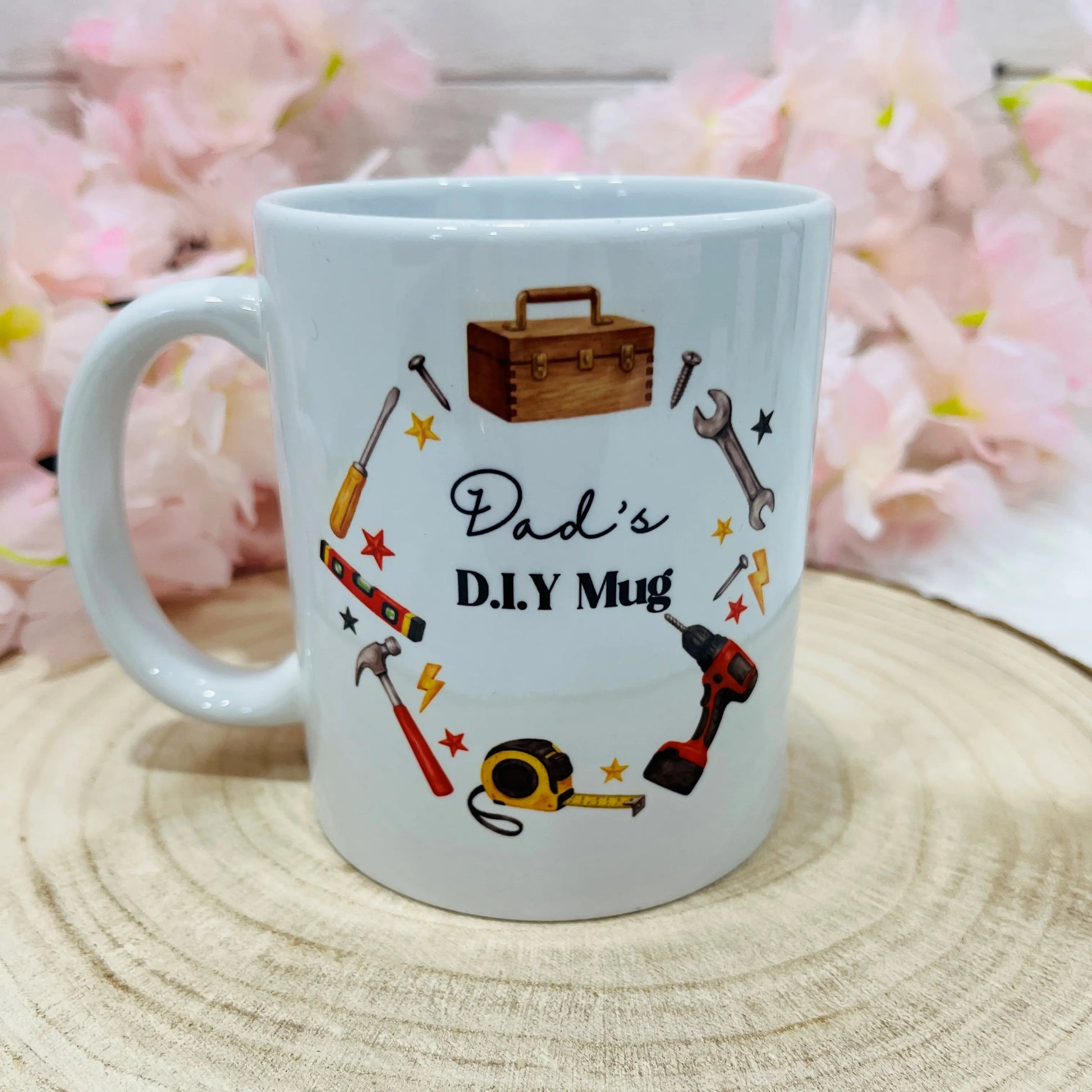 White mug with tool illustrations and 'Dad's D.I.Y Mug' text on a wooden surface 
