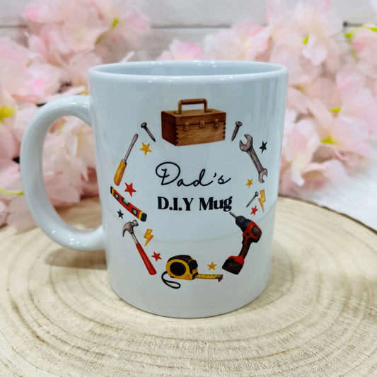 White mug with tool illustrations and 'Dad's D.I.Y Mug' text on a wooden surface 