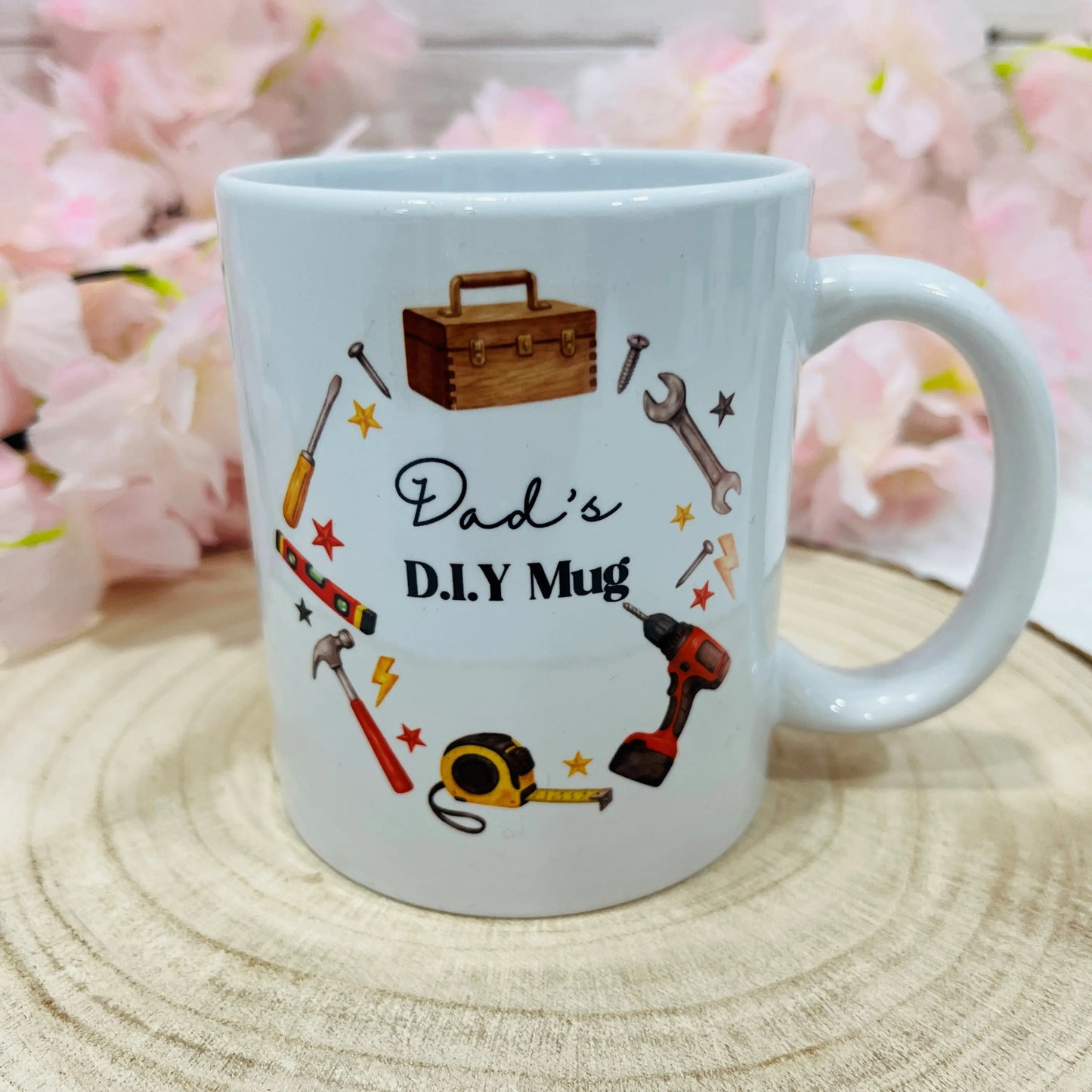 White mug with 'Dad's D.I.Y Mug' text and tool illustrations on a wooden surface 