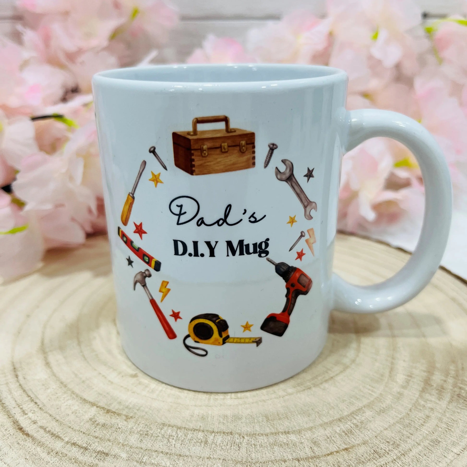 White mug with 'Dad's D.I.Y Mug' text and tool illustrations on a wooden surface 