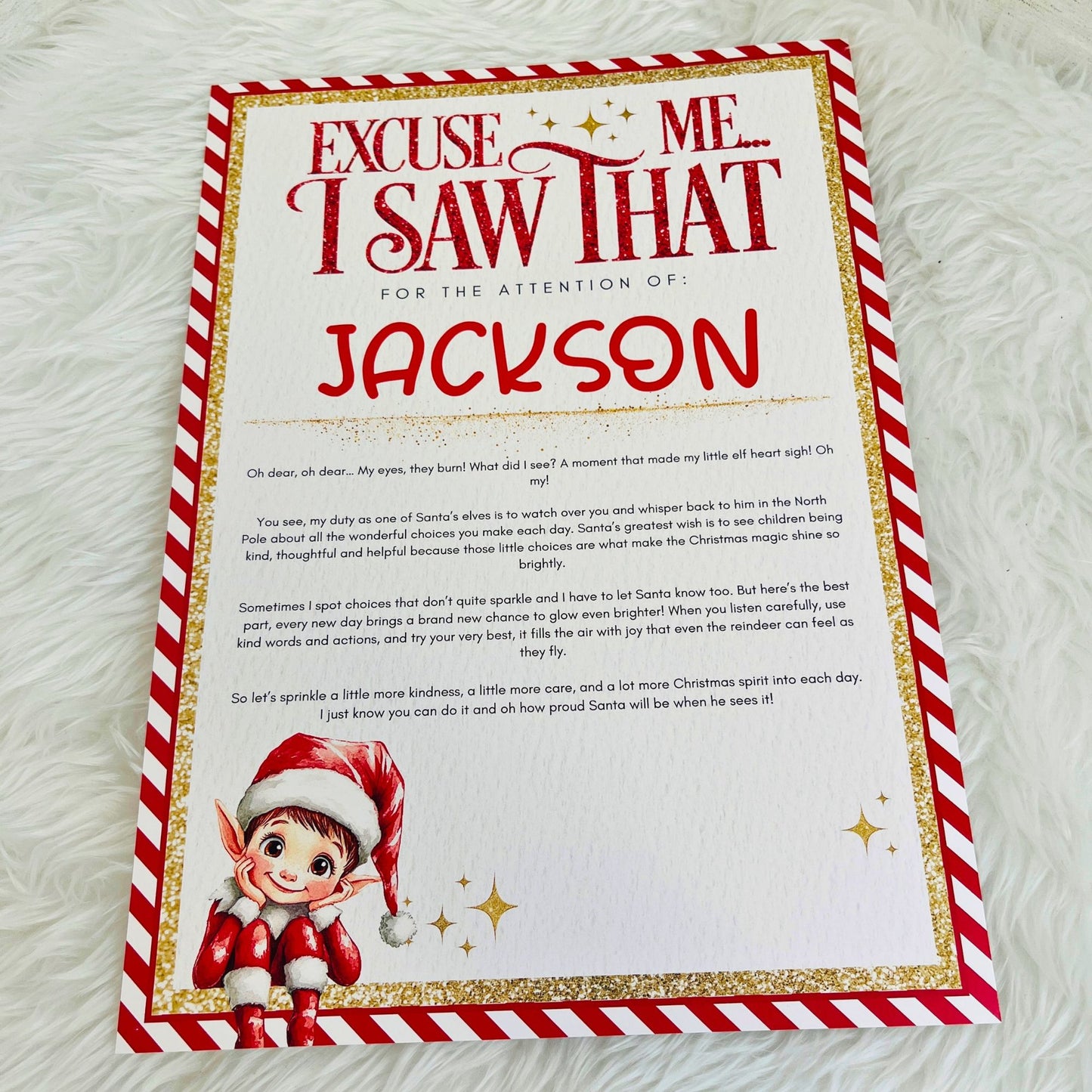 A personalised Christmas letter print for a child, featuring a red and white striped border, gold glitter-style accents, and a cartoon elf illustration at the bottom left. The text reads 'Excuse Me I Saw That For The Attention Of: Jackson' followed by a handwritten-style message.
