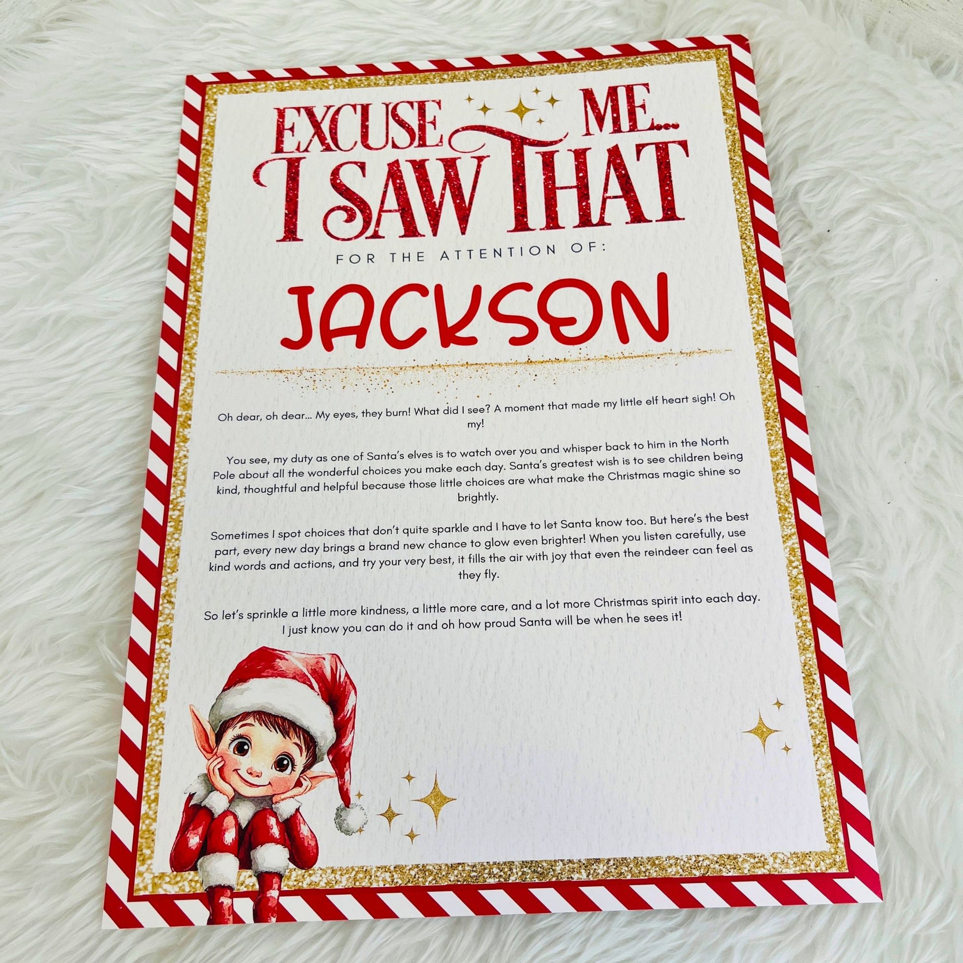 A personalised Christmas letter print for a child, featuring a red and white striped border, gold glitter-style accents, and a cartoon elf illustration at the bottom left. The text reads 'Excuse Me I Saw That For The Attention Of: Jackson' followed by a handwritten-style message.