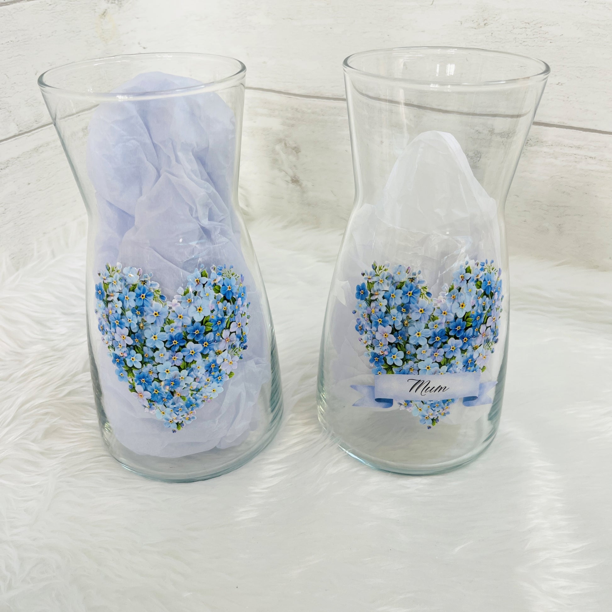 Two glass vases with forget me not design and the text 'mum' on the front against a white background