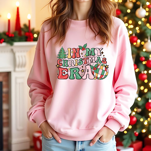 A lady wearing a pink jumper with 'In my Christmas Era' on the front in a colourful design