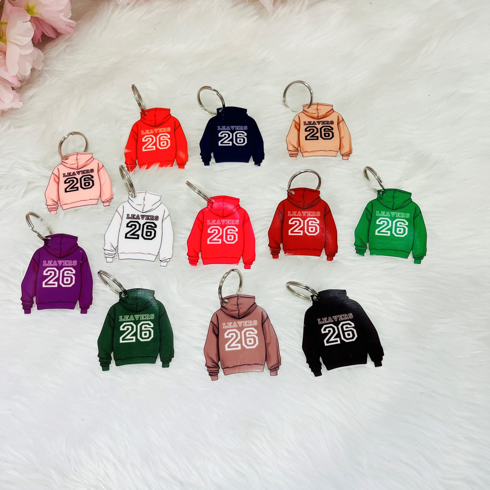 Keychains shaped like colorful hoodie sweatshirts with the number 26 on a white background.
