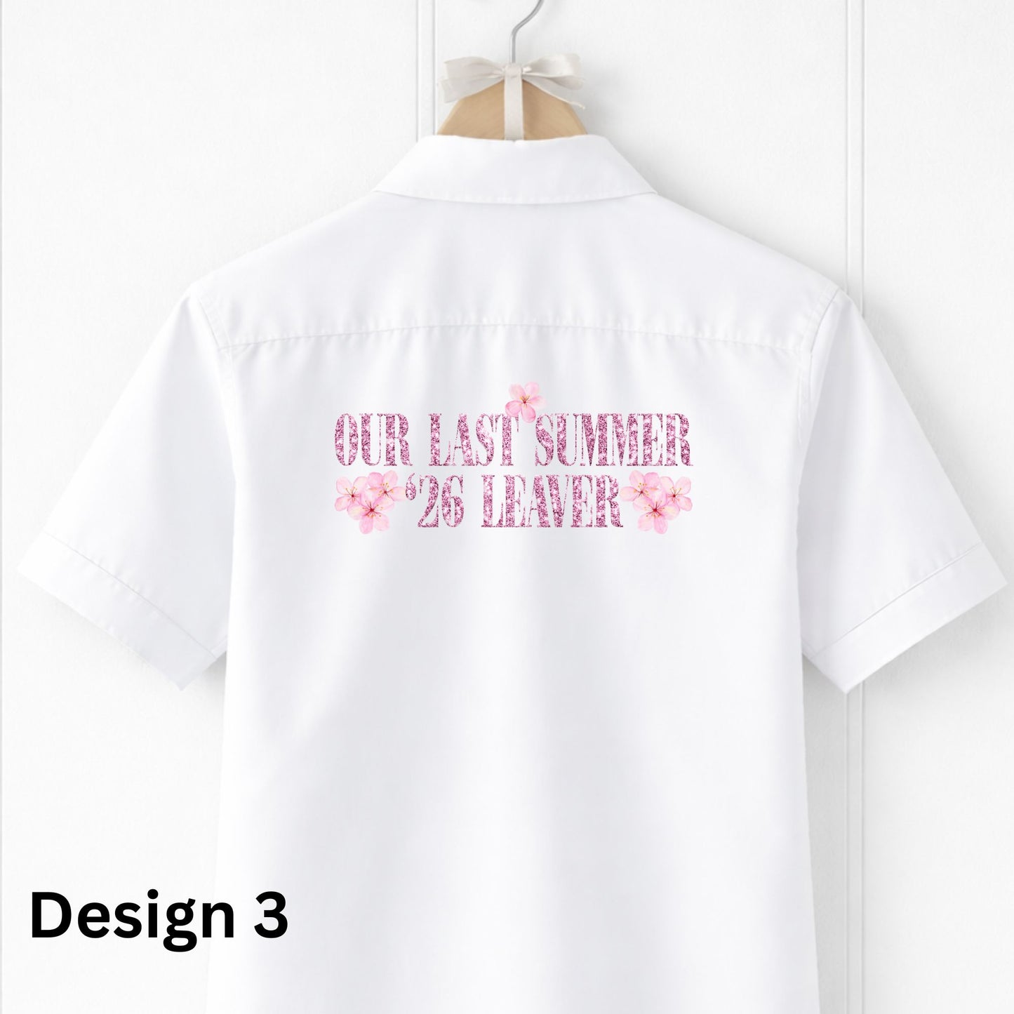 White shirt with pink text and floral designs on a hanger against a white background