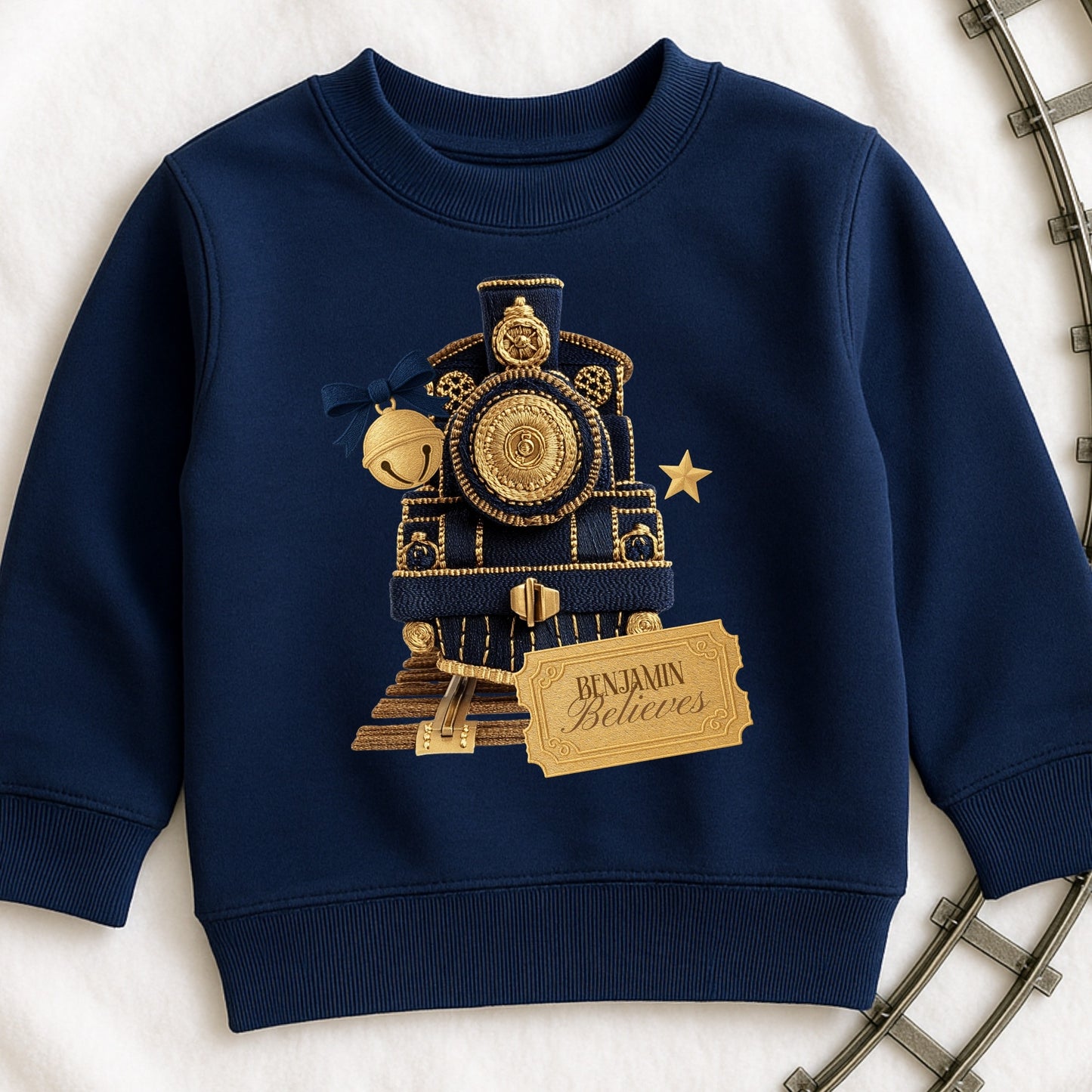 Navy blue sweatshirt with gold train design and 'Benjamin Believes' tag on a light background