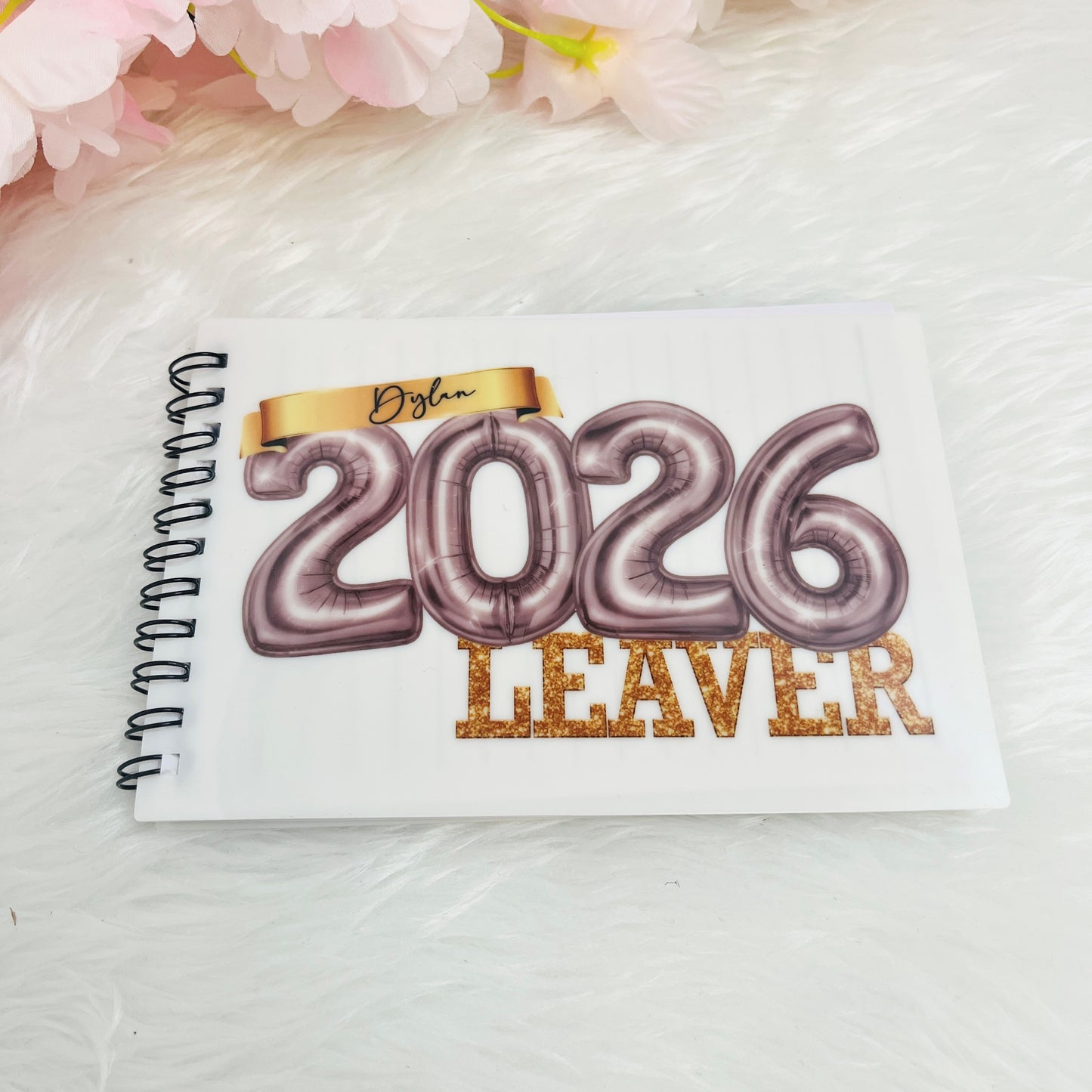 Notebook with '2026 Leaver' design in silver on a white background with pink flowers.