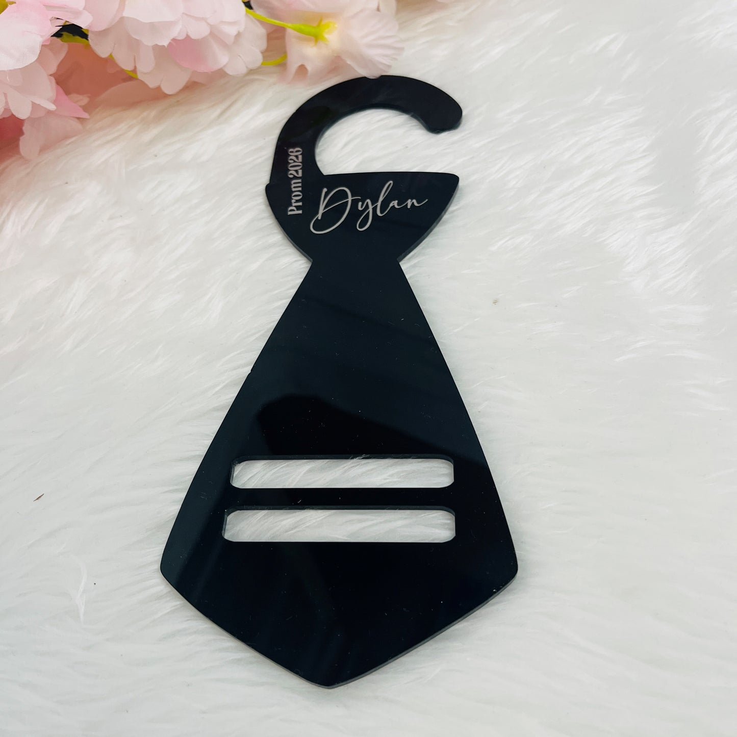 Black plastic tie hanger with 'Dylan' and Prom 2026 in silver vinyl on a white background