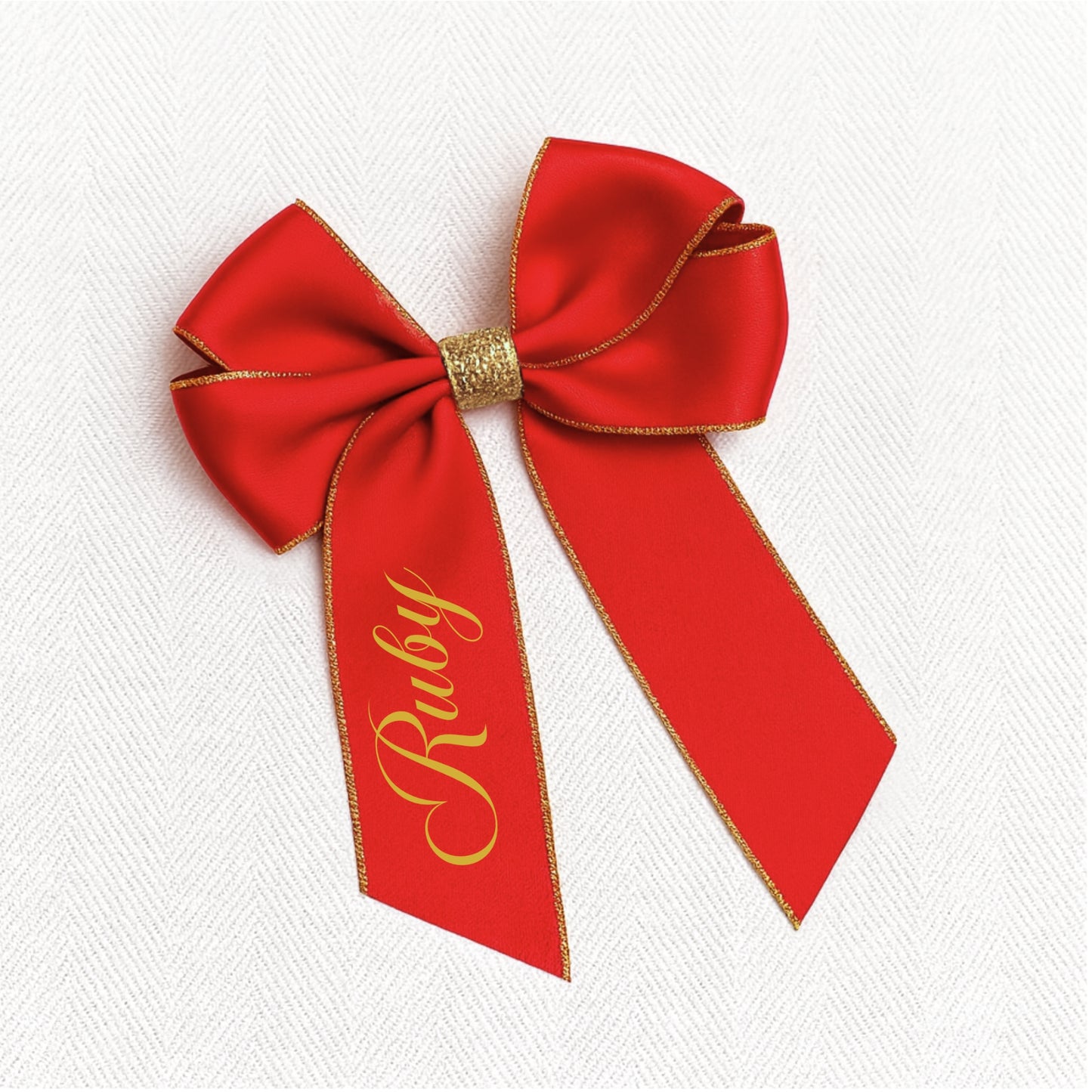 Red bow with gold trim and 'Ruby' text on a white background