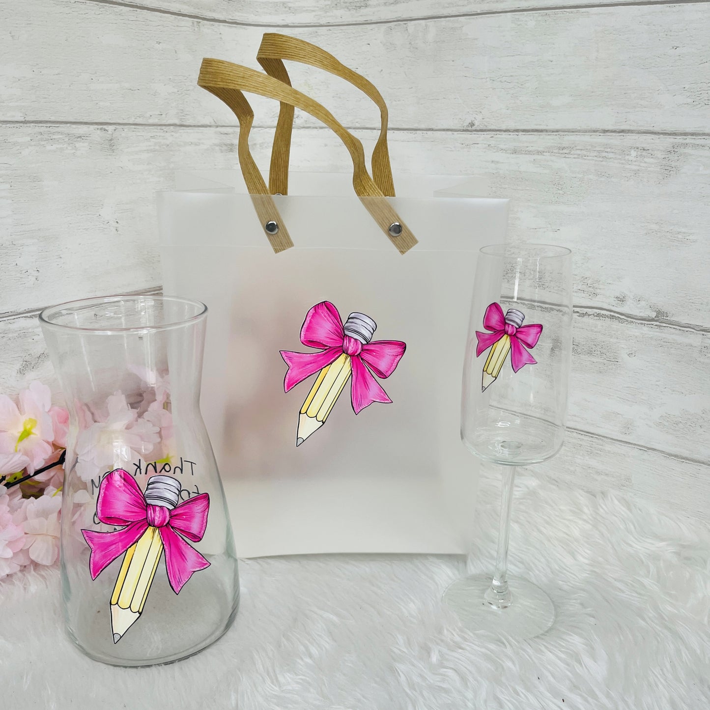 A glass Vase, champagne flute and frosted gift bag with a pencil design and text on the vase 'thank you for helping me grow'