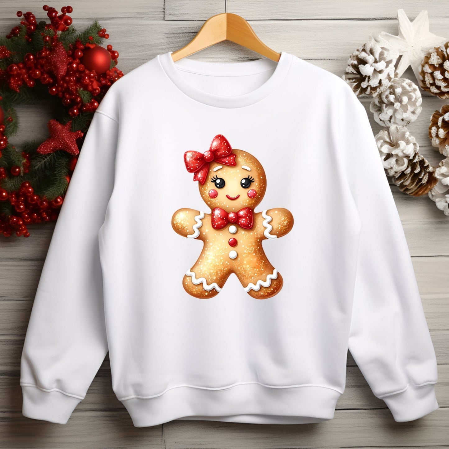 White sweatshirt with a gingerbread girl design on a wooden background with Christmas decorations.