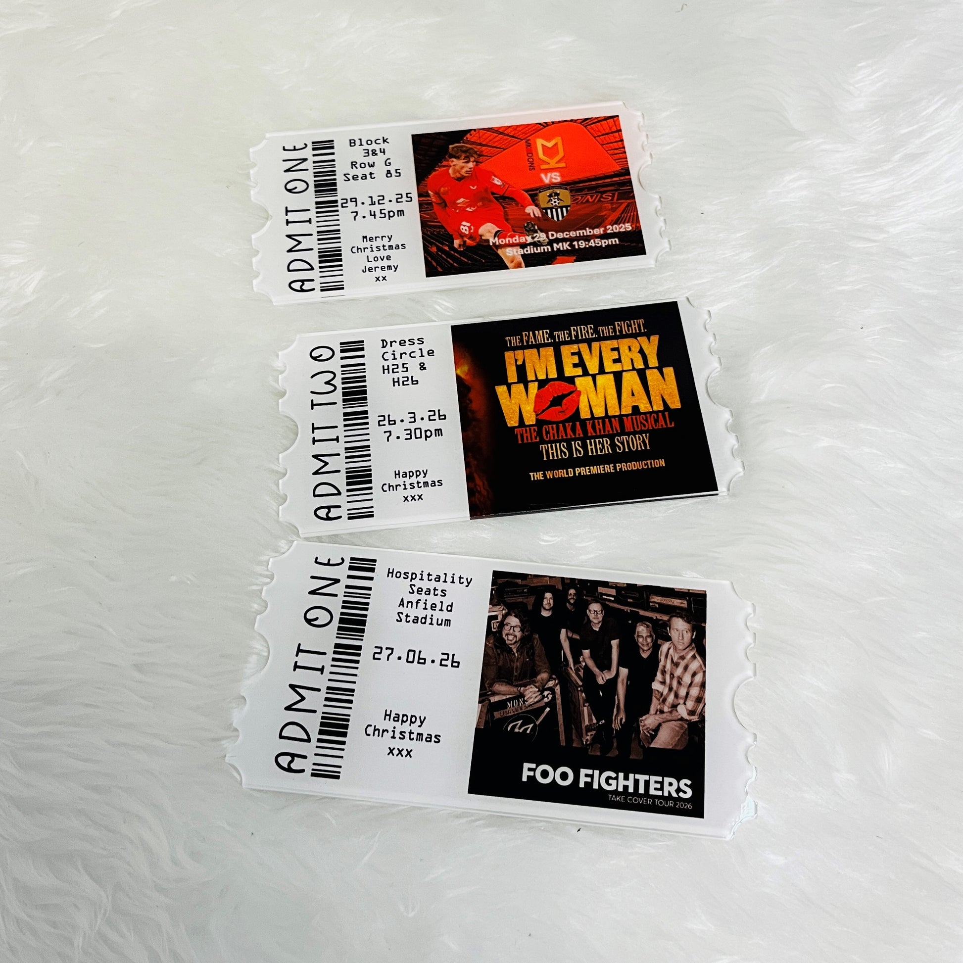 Three concert tickets with images and text on a white background