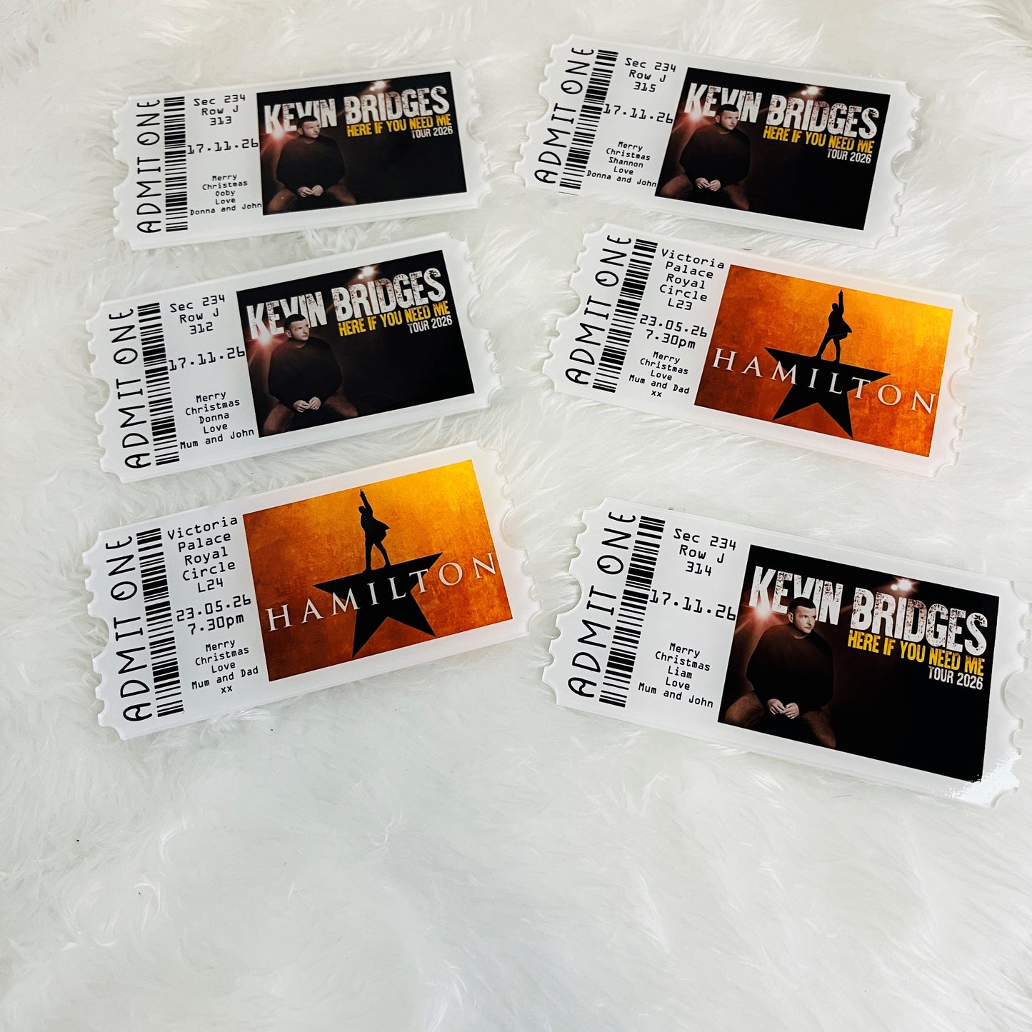 Set of acrylic keepsake concert tickets for Kevin Bridges and Hamilton on a textured surface