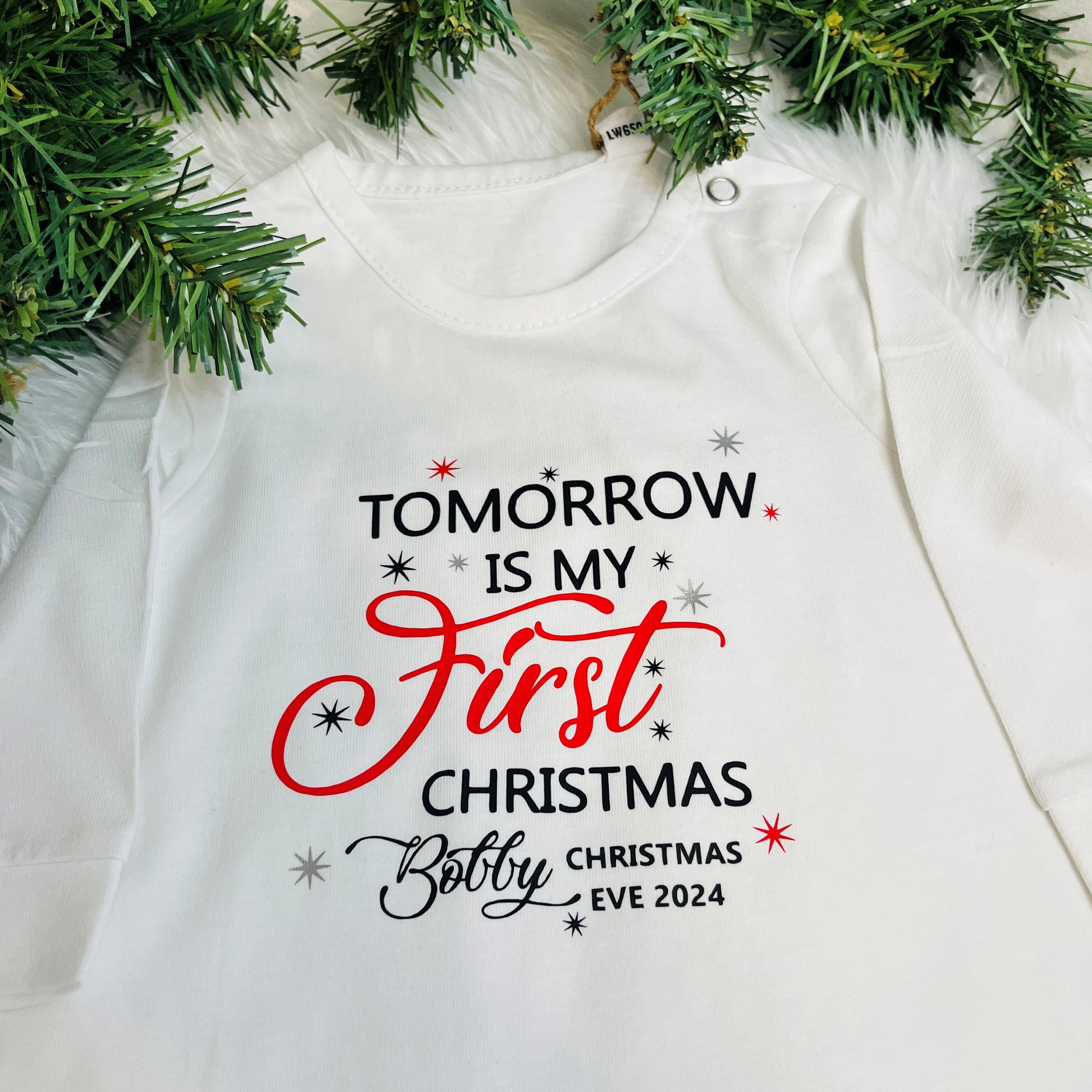 Personalised white sleepsuit with 'My first Christmas Eve' and the name 'Bobby'