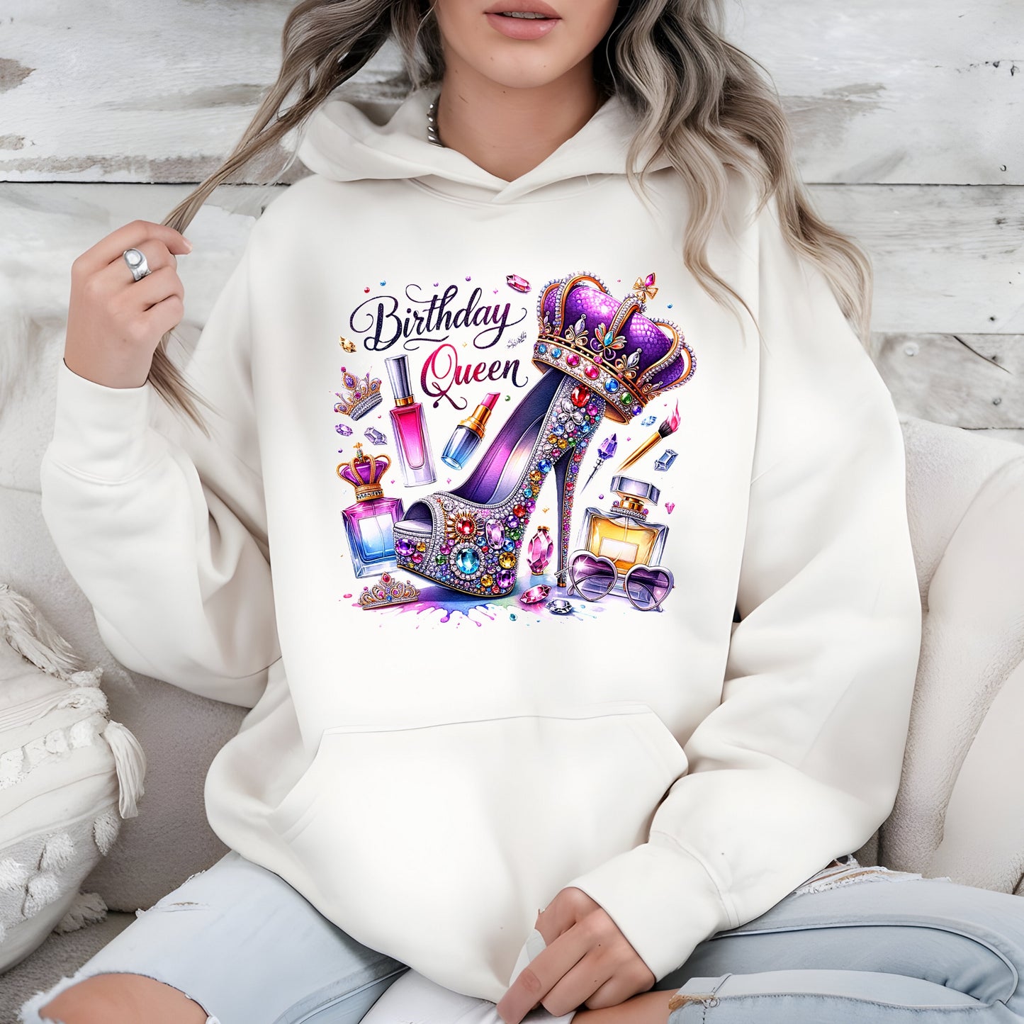 Person wearing a white hoodie with a 'Birthday Queen' design featuring high heels and perfume bottles.