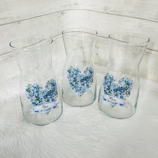 Three glass vases with a forget me not design on the front