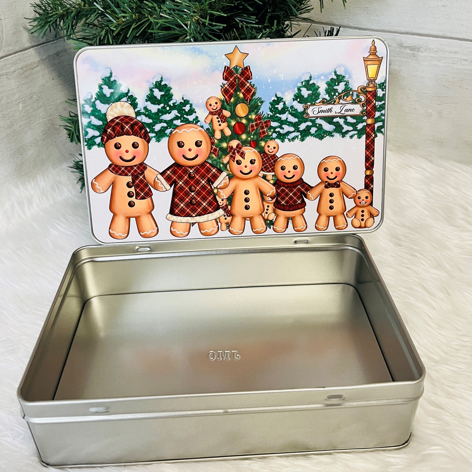 Metallic cookie tin with gingerbread family design on a white background