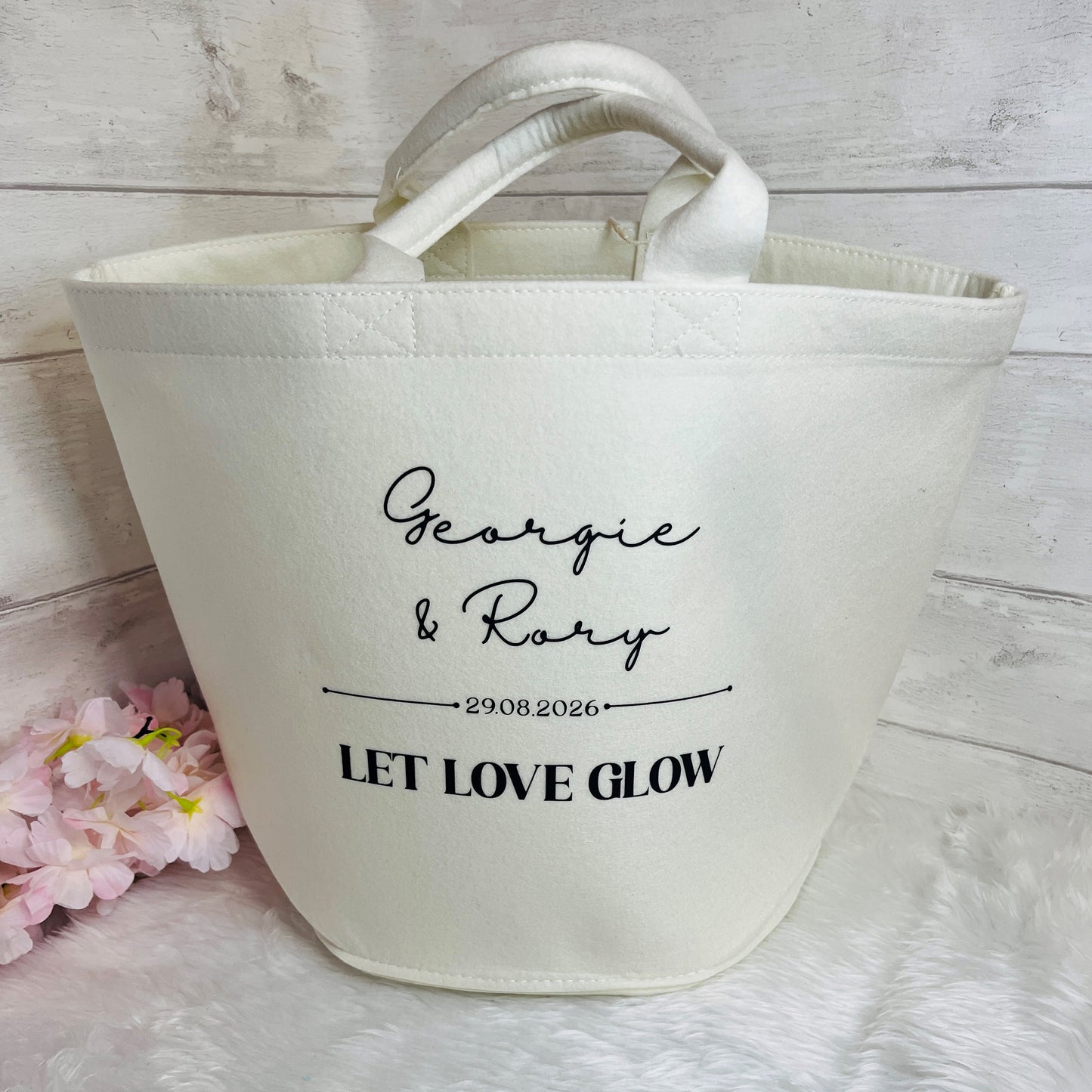 An off-white felt trug bag with custom black printed text reading 'Georgie & Rory', '29.08.2026