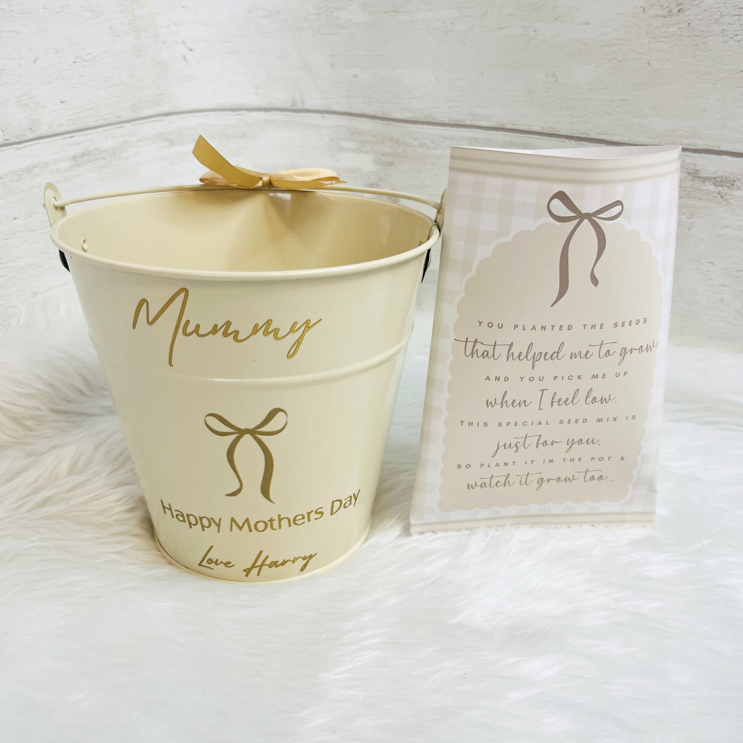 Beige bucket with 'Mummy' and 'Happy Mother's Day' text, accompanied by a matching seed packet on a white background.