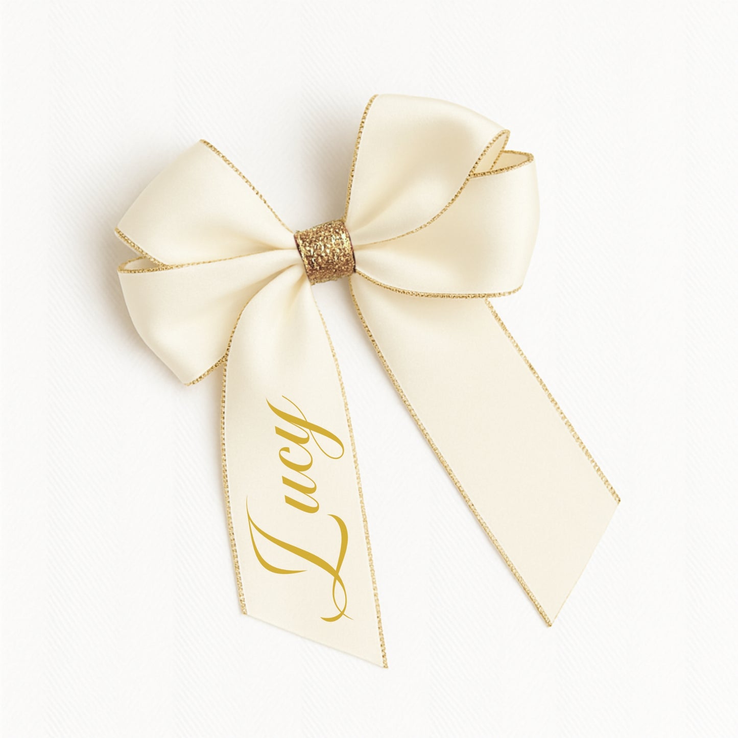 Ivory-colored bow with gold trim and 'Lucy' text on a white background