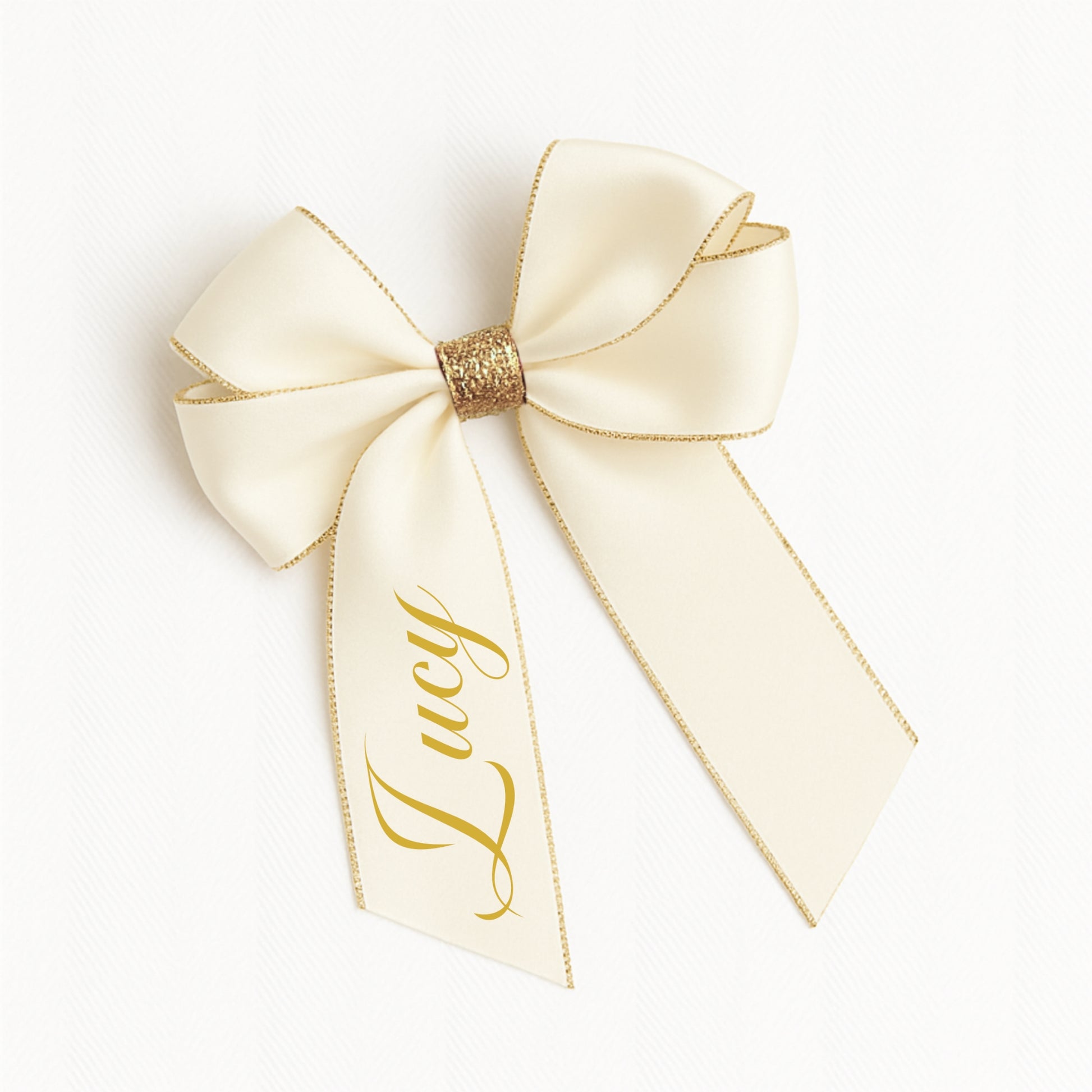 Ivory-colored bow with gold trim and 'Lucy' text on a white background