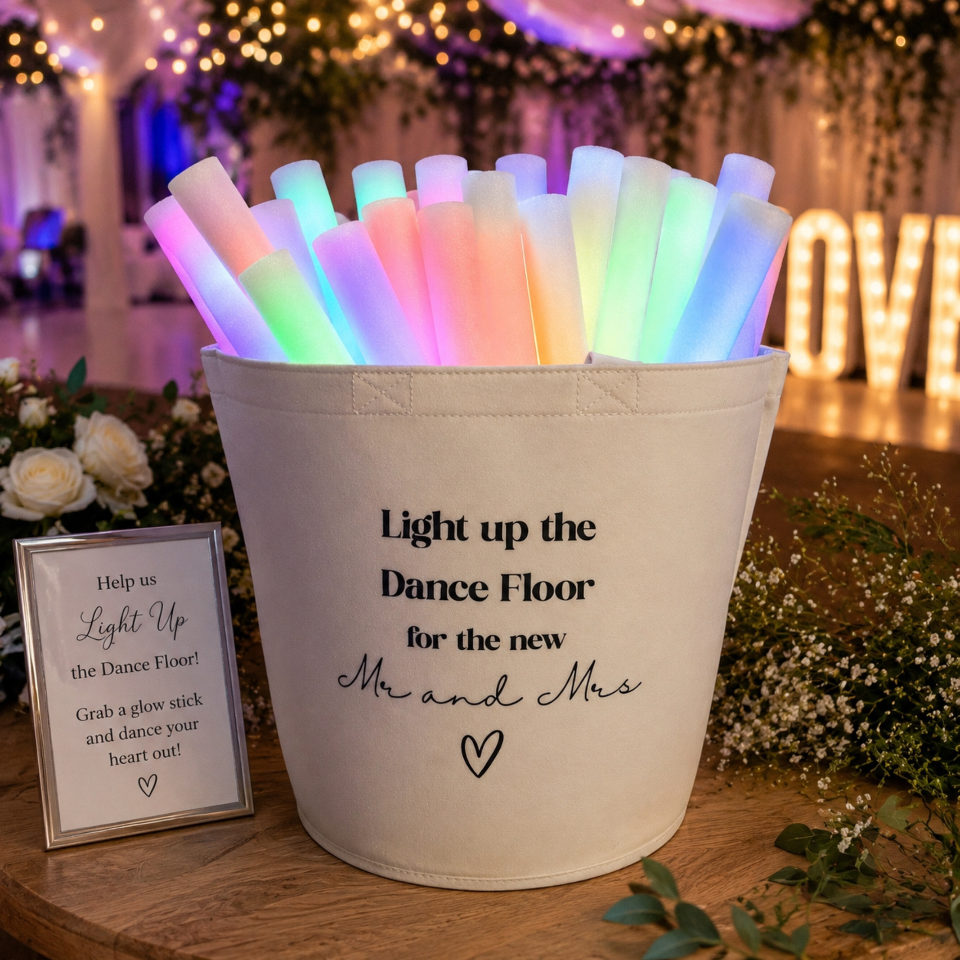 Ivory Felt Trug full of colorful glow sticks with a wedding-themed message 'Light up the Dance Floor for the new Mr and Mrs' on a decorated dance floor.
