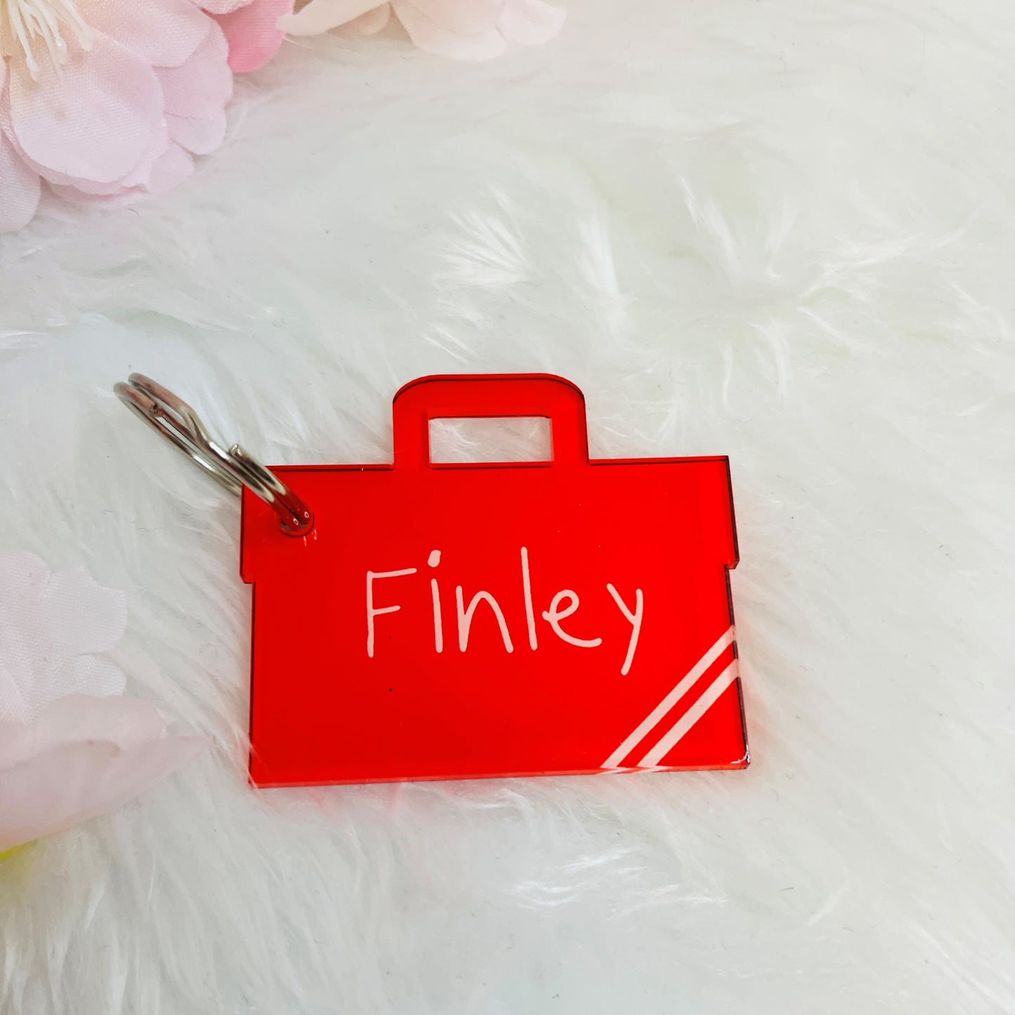Waterproof acrylic name tag keyring attached to a school book bag