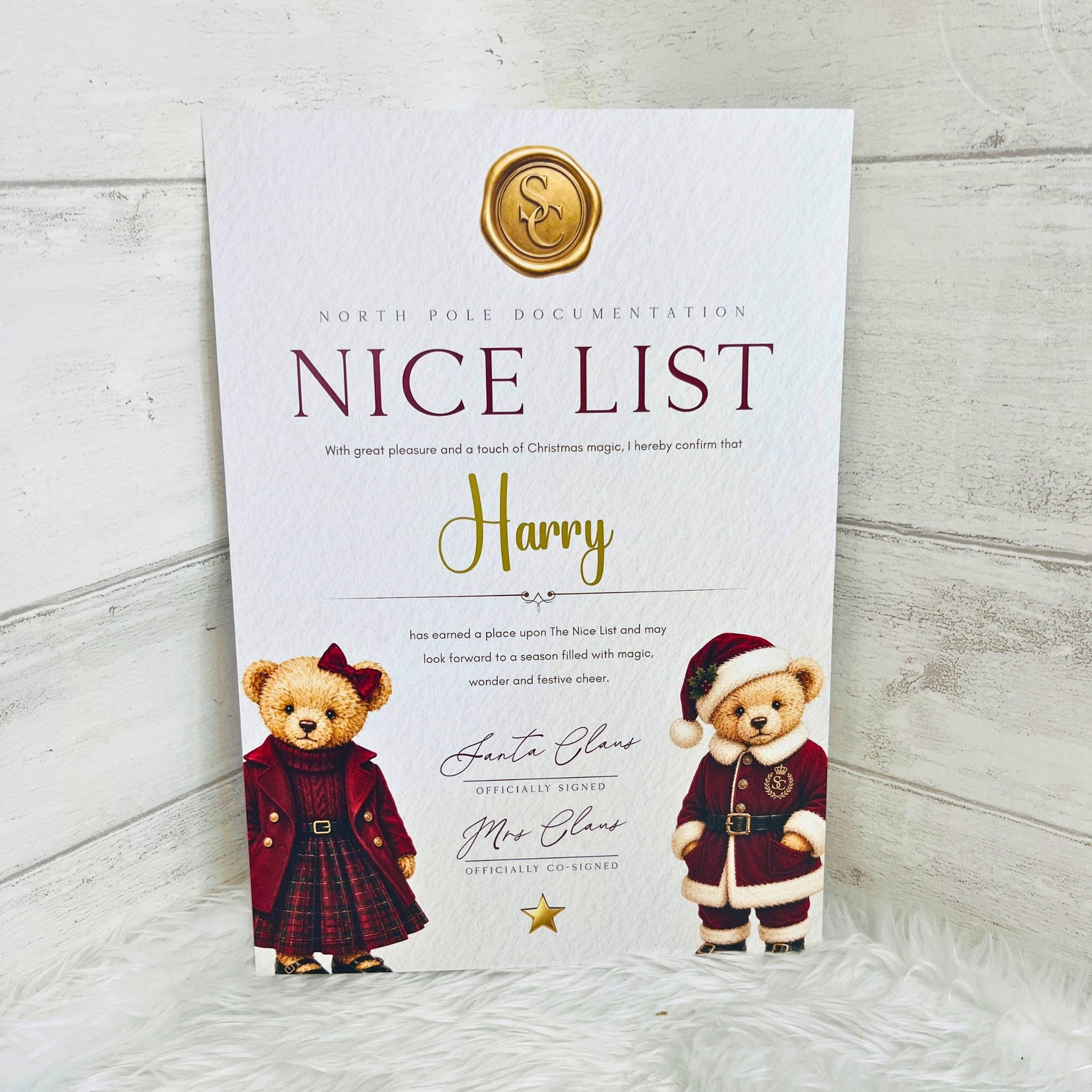 A custom printed 'Nice List' document for Santa Claus, featuring a gold wax seal, decorative text, and illustrations of two teddy bears dressed as Santa Claus on a white textured background.