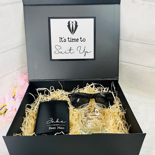 Gift set with sunglasses, glass, and black Hip Flask in a black box with 'Suit Up' text.