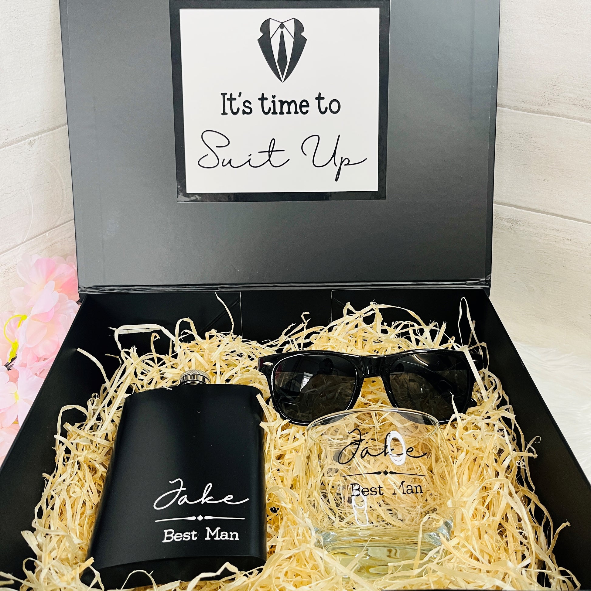 Gift set with flask, glass, and sunglasses in a black box labeled 'It's time to Suit Up'.