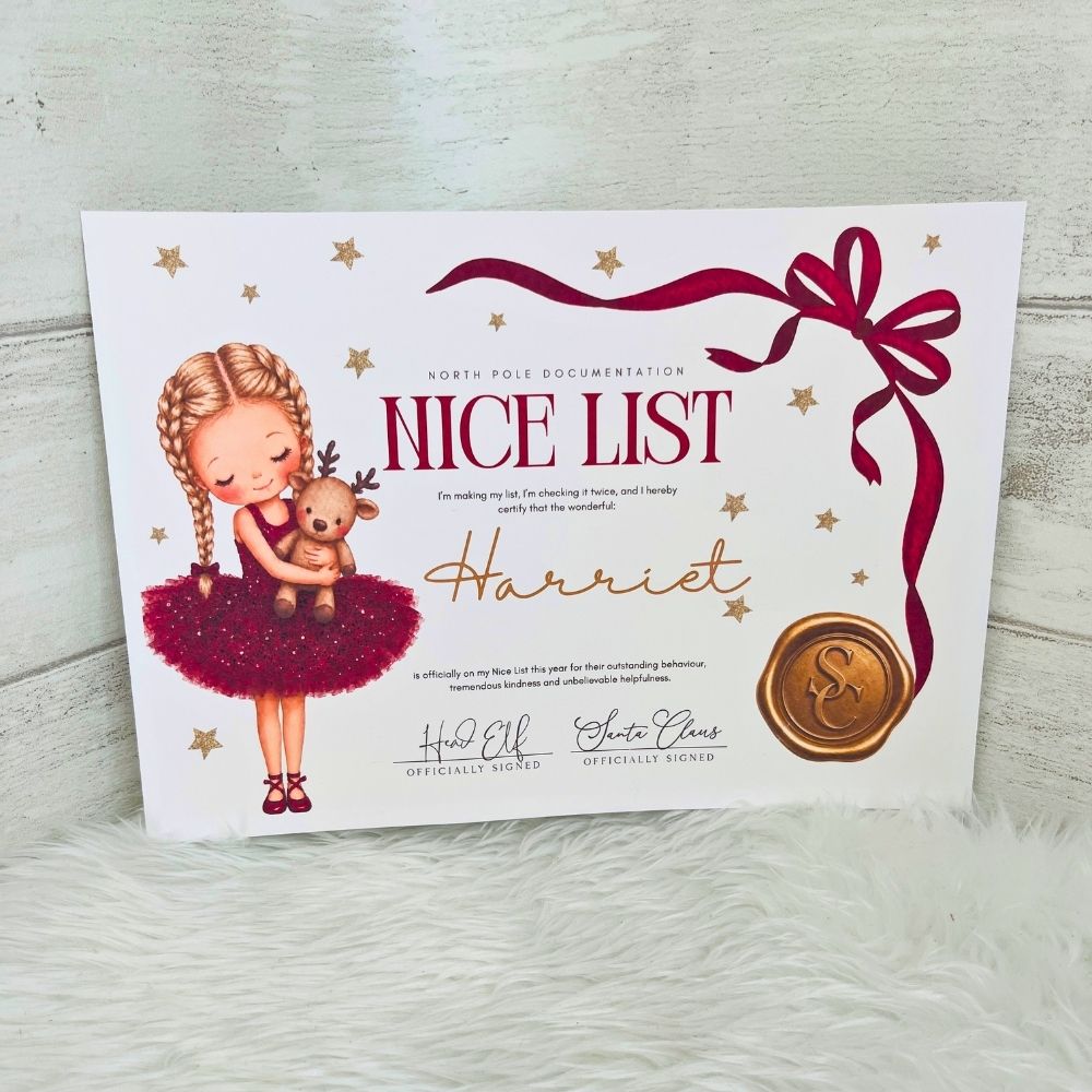 An A5 personalised Christmas 'Nice List' card featuring an illustration of a girl in a red tutu holding a teddy bear, with the name 'Harriet' in gold script and a gold wax seal illustration, displayed on a white faux fur surface against a light wood background.